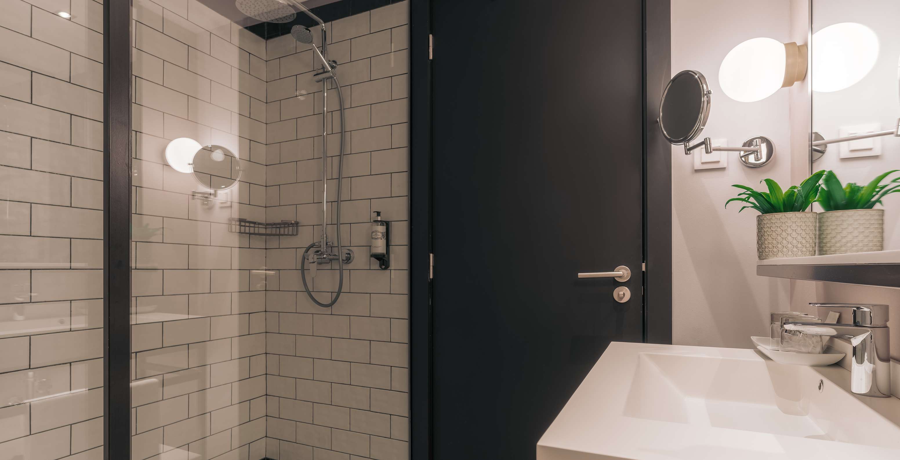 La Rooftop Junior Suite del Pestana Lisboa Vintage tiene un baño con ducha con puertas de vidrio y dos espejos