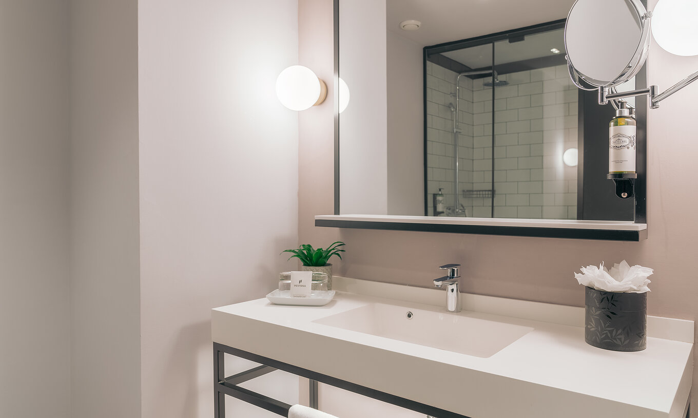 El Double Classic del Pestana Lisboa Vintage tiene un baño con lavabo con dos espejos y dos luces laterales