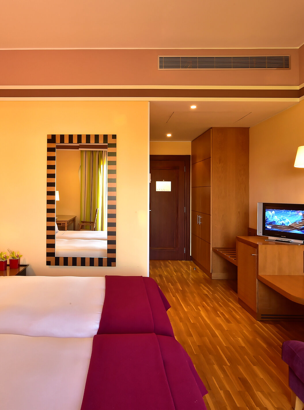 El Duplo Clássico del Pestana Sintra Golf tiene dos camas, un espejo en la pared y un mueble con una pequeña televisión