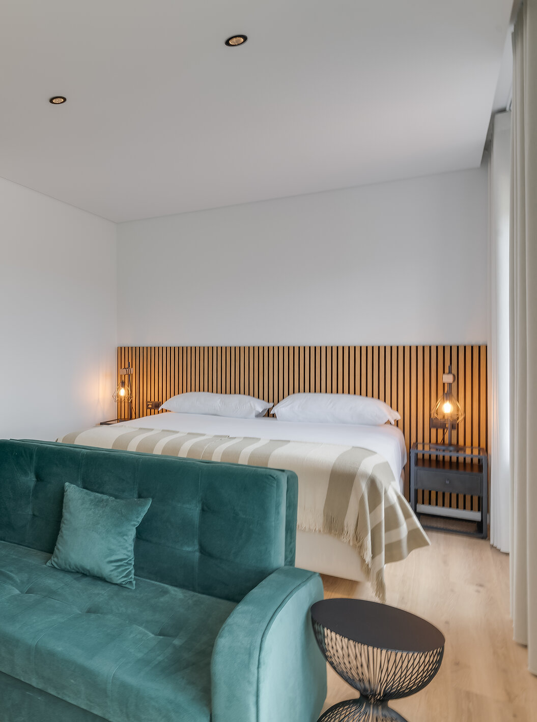 El Familiar con Terraza - Clubhouse del Pestana Sintra Golf tiene una cama de matrimonio con cabecero de madera y sofá