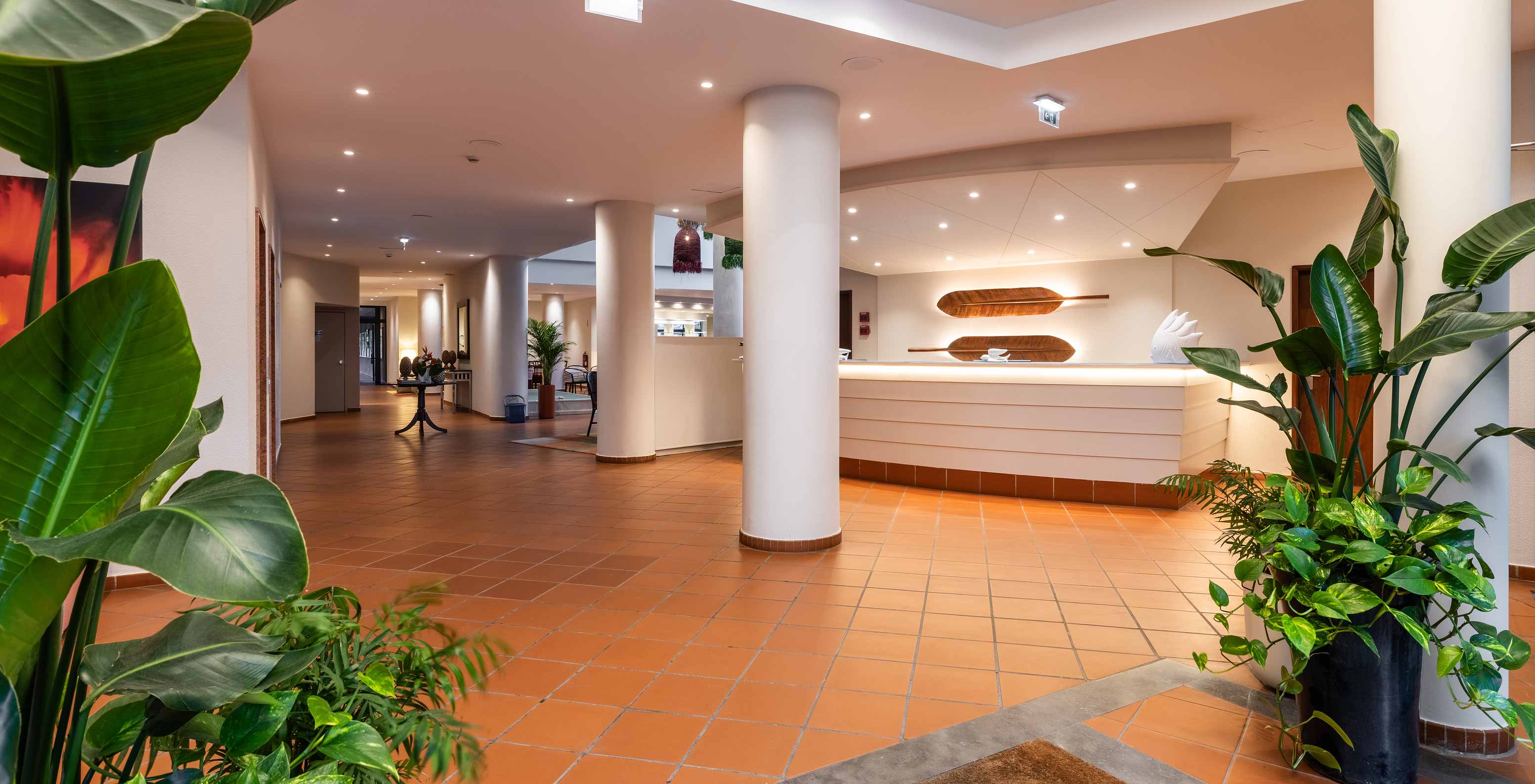Pestana Ocean Bay All Inclusive, un hotel todo incluido con una recepción blanca decorada con plantas