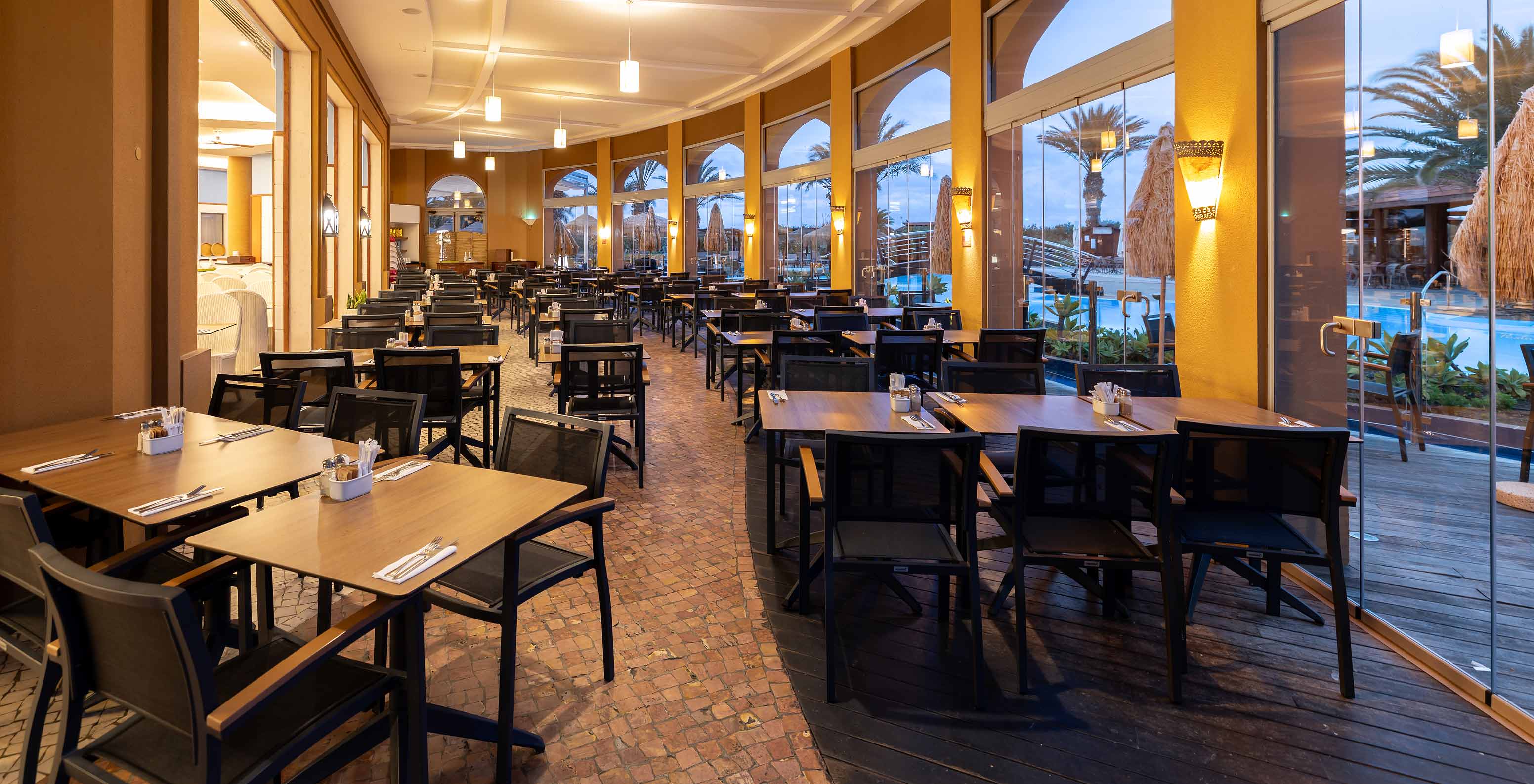 El restaurante Marés, del Resort de 5 estrellas en Porto Santo, tiene una zona exterior con mesas cuadradas y sillas.