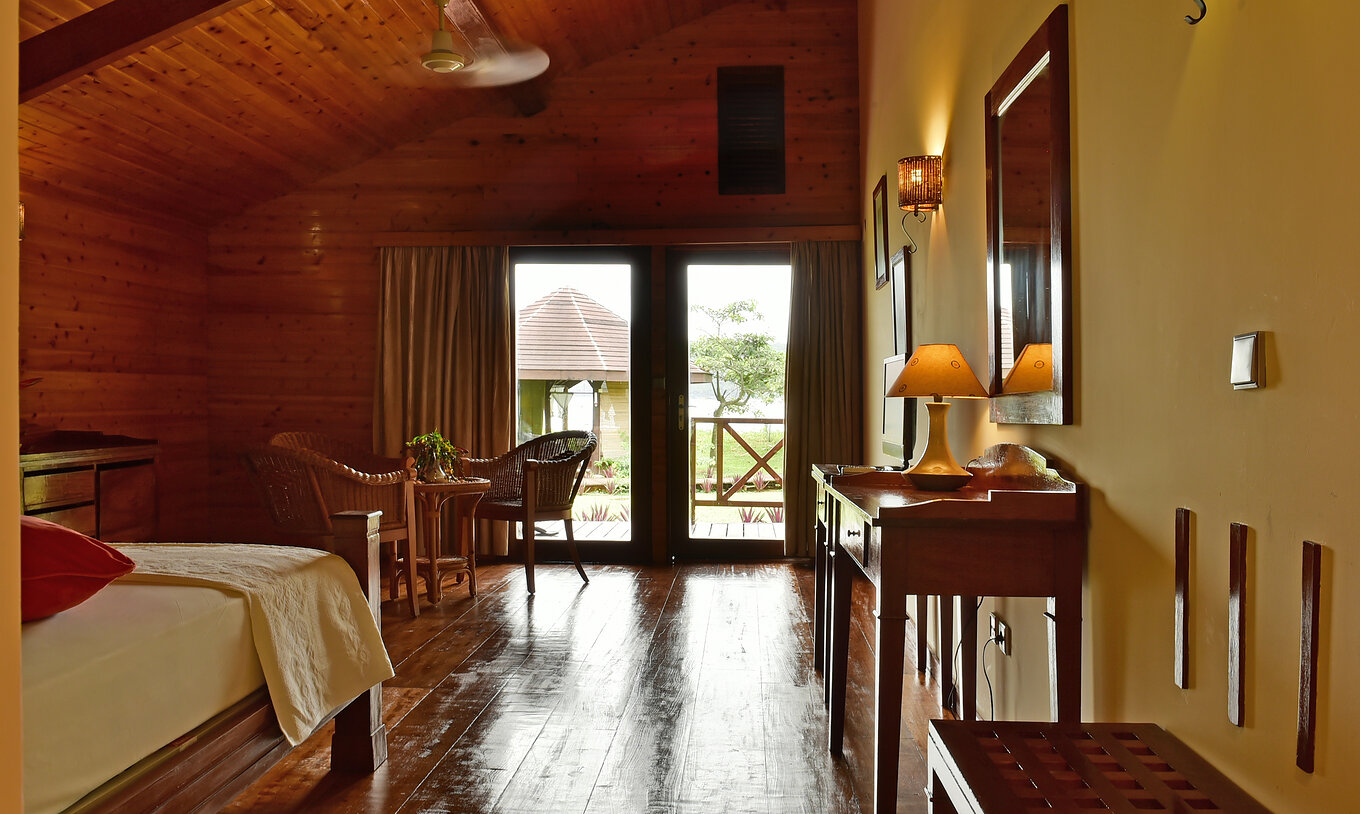 El Duplo Superior del Pestana Equador Ilheu das Rolas tiene una cómoda de madera, un espejo y ventana con vista al jardín