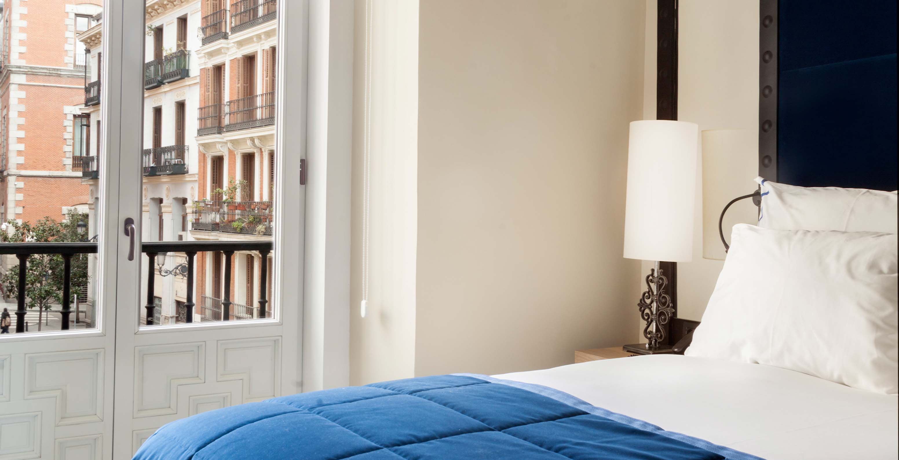 El Superior Plaza Mayor del Pestana Collection Plaza Mayor tiene una cama, un lámpara en la mesa de noche y una ventana