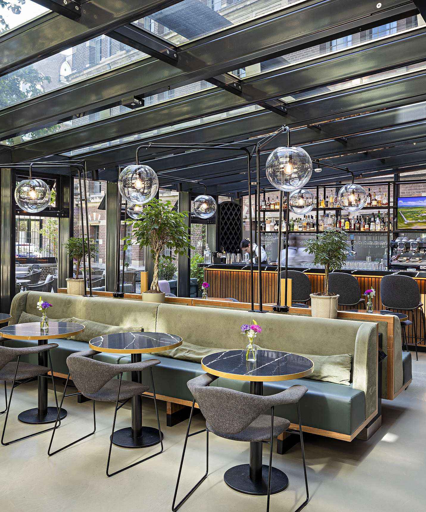 Pestana Amsterdam Riverside, hotel en el centro de Ámsterdam, con un restaurante amplio, mesas y paredes de vidrio