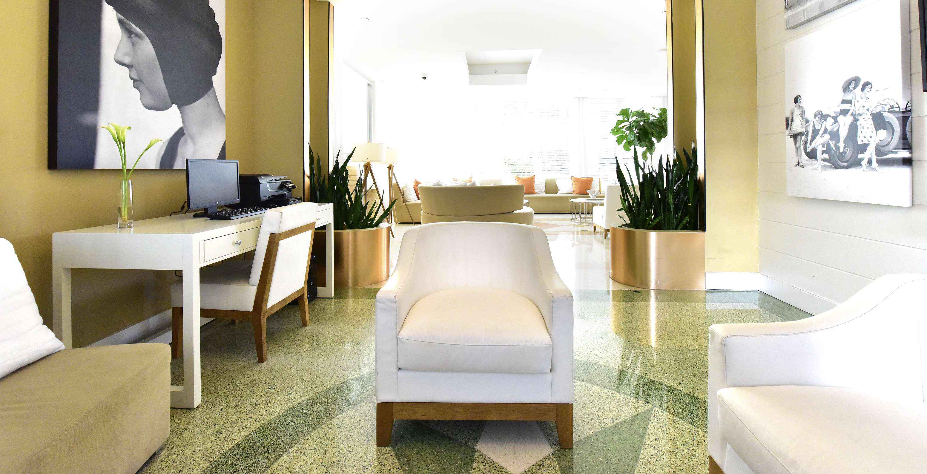 Área de trabajo en el vestíbulo del hotel equipada con computadora fotocopiadora escritorio y sillas