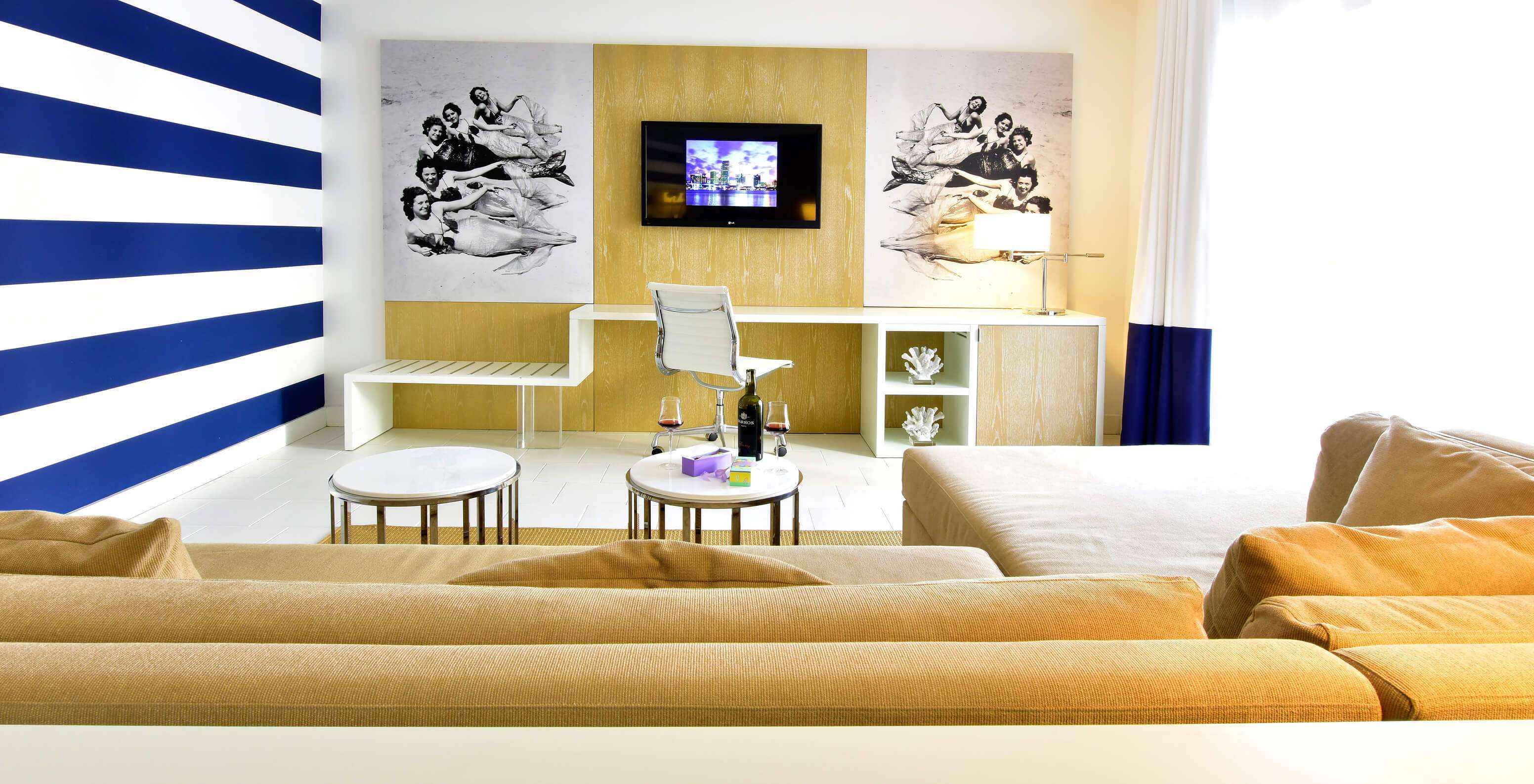 La Suite King con balcón del Pestana Miami South Beach cuenta con una sala con sofá con chaise longue, escritorio y televisor