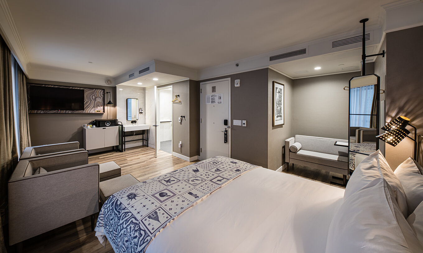 La Junior Suite - ADA del Pestana Park Avenue cuenta con una sala de estar con sofá y sillones, caja fuerte y televisión