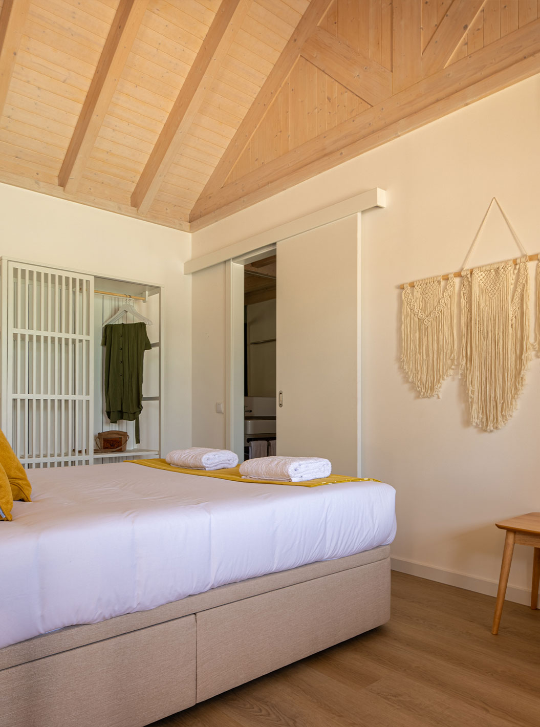 La Standard Green Villa de Pestana Comporta Village Residences tiene un dormitorio minimalista con una cama y un banco