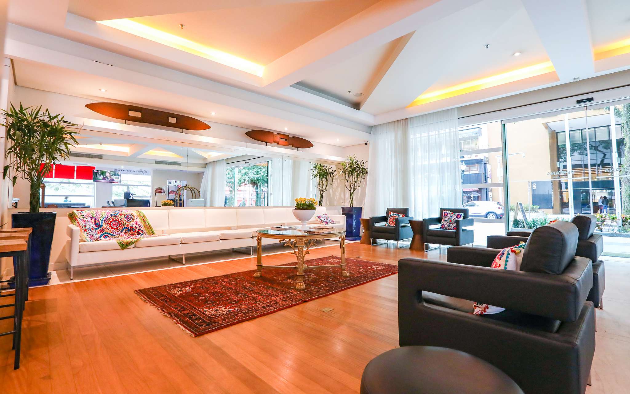 Ingang Pestana Curitiba, 4 fauteuils en lange witte sofa met kleurrijke kussens