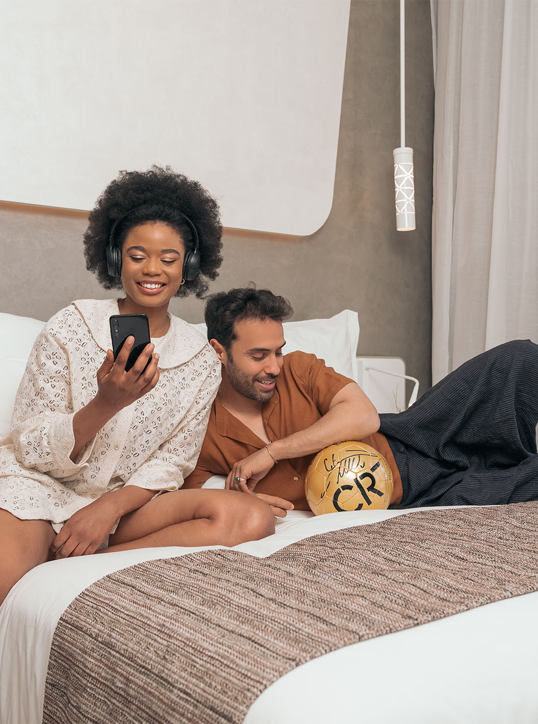 De CR7 Superior van Pestana CR7 Marrakech heeft een tweepersoonsbed met een glimlachend paar, met een voetbal van CR7