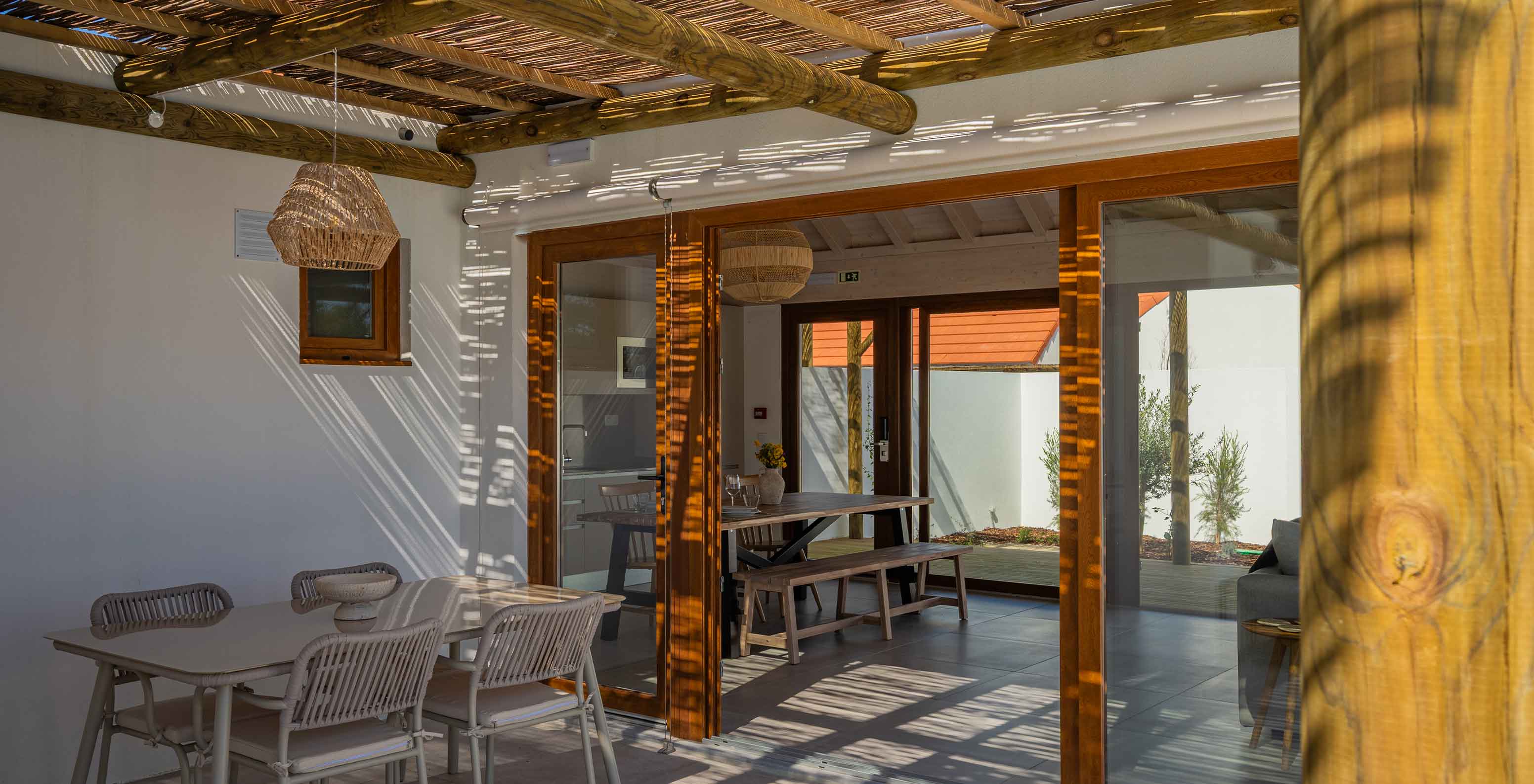 De Premium Groene Villa bij Pestana Comporta Village Residences heeft een overdekte patio met een tafel die naar binnen leidt