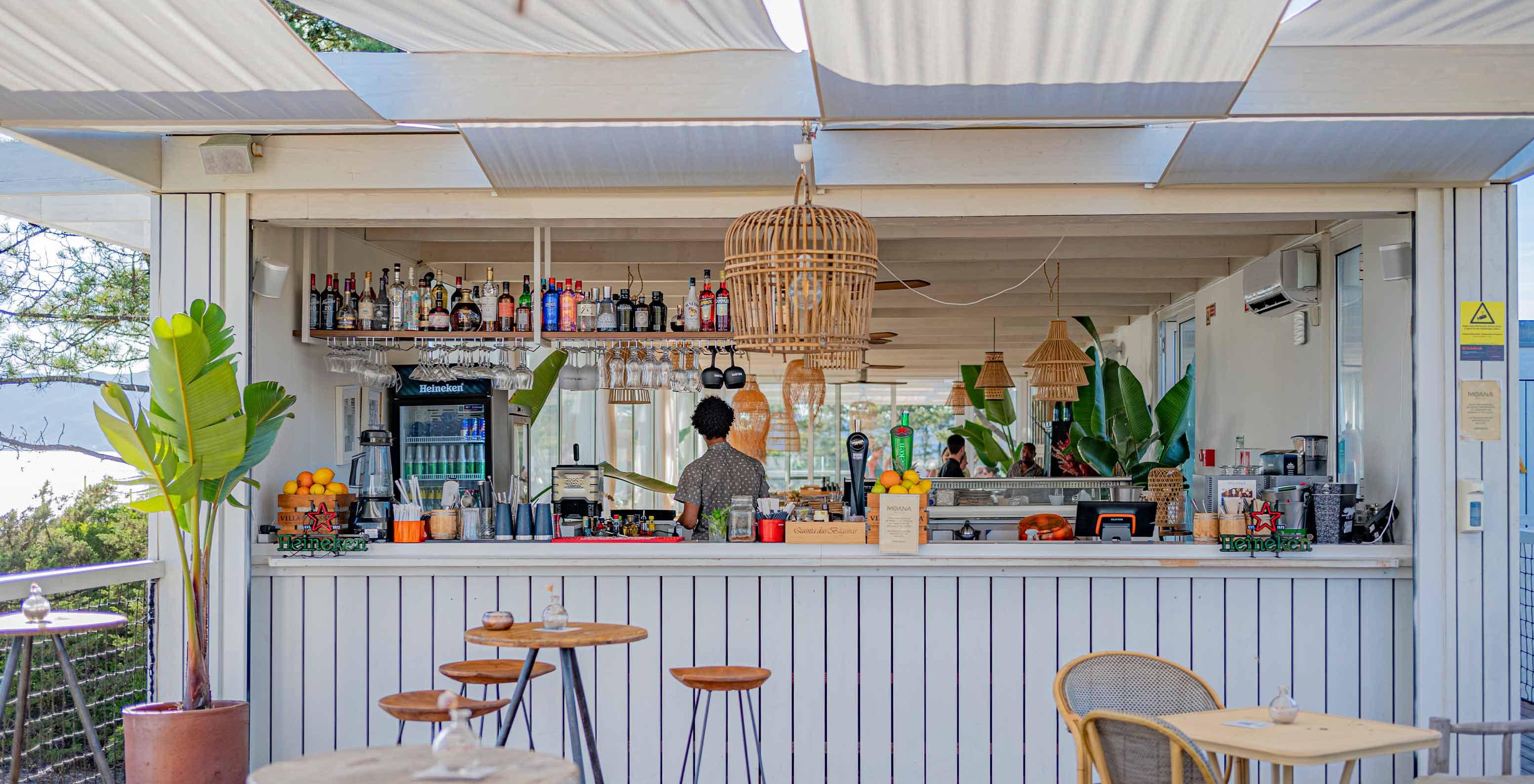 De Moana Beach Club bar in Pestana Tróia Eco Resort heeft houten tafels, stoelen en een drankentoonbank