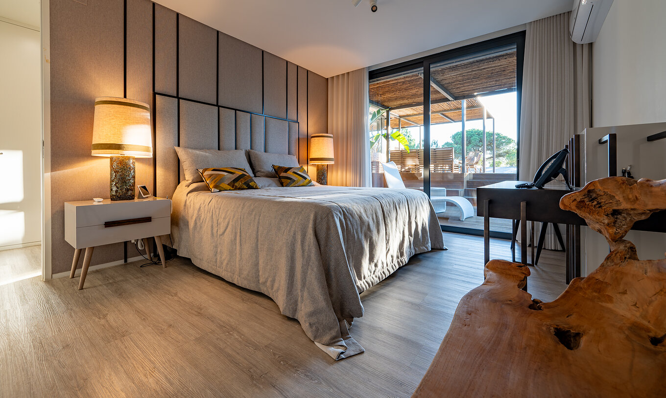 De Luxe 4 Slaapkamer Villas met Privézwembad van Pestana Tróia Eco Resort hebben een tweepersoonsbed met toegang tot het terras