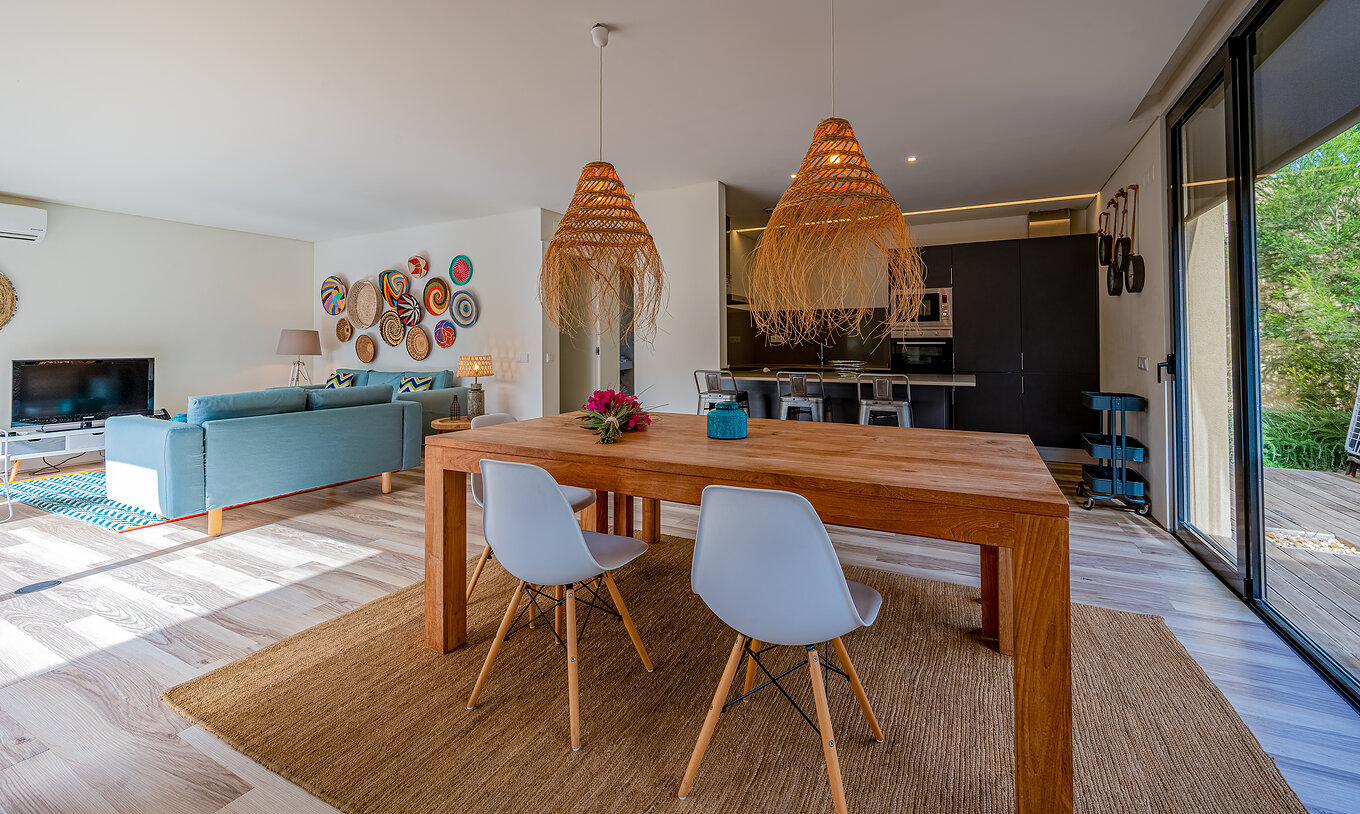 De Pine Villas van Pestana Tróia Eco Resort hebben een woonkamer met houten tafel, lampen en keuken