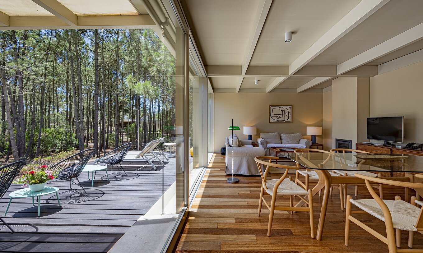 De Townhouse van Pestana Tróia Eco Resort heeft een woonkamer met banken en toegang tot het terras