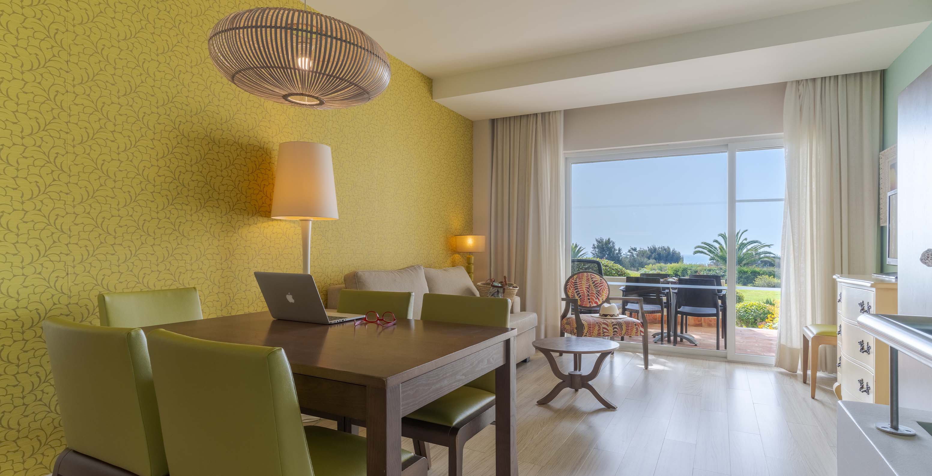 De Suite T2 Duplex met uitzicht op de zee van Pestana Alvor Praia heeft woonkamer met eettafel, stoelen, bank en balkon