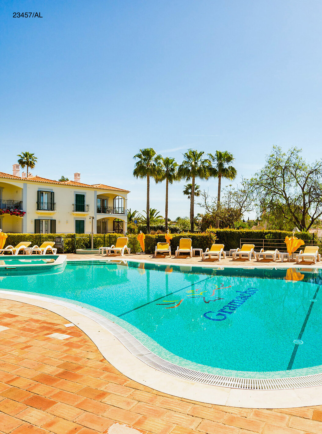 Het appartement Pestana Carvoeiro Golf T3 Standard heeft een buitenruimte met een zwembad en gele ligstoelen