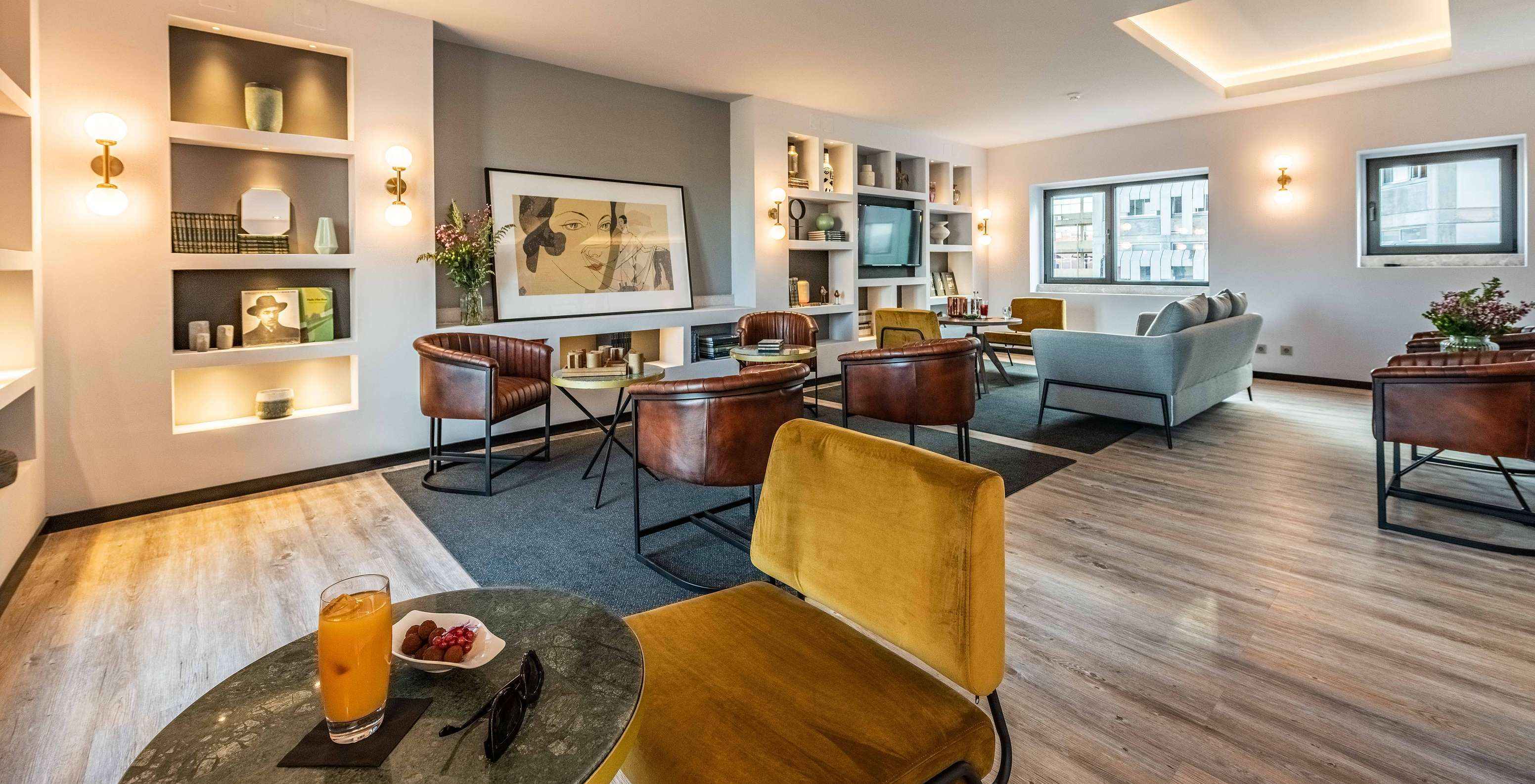 Lounge met banken, stoelen, tafels, schilderijen, televisie, tapijten en decoratieve voorwerpen met uitzicht op de stad