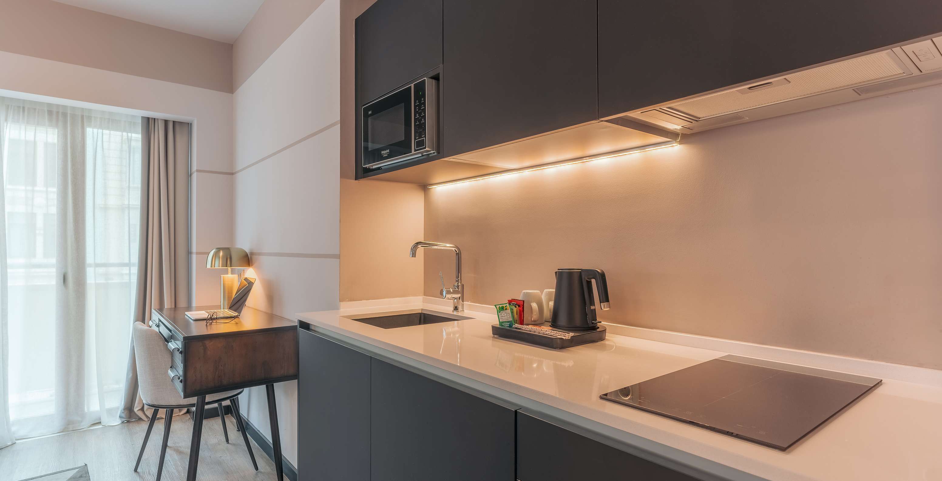 De Junior Suite Van Pestana Lisboa Vintage Heeft Een Keukenkast Met Kookplaat Magnetron En Een Bureau Met Stoel