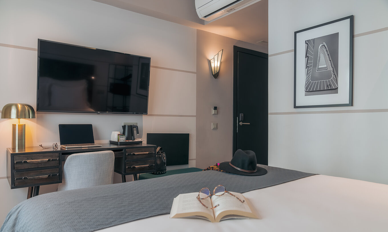 De Vintage Van Pestana Lisboa Vintage Heeft Een Tweepersoonsbed Met Een Grijze Deken Een Bureau Met Computer En Televisie