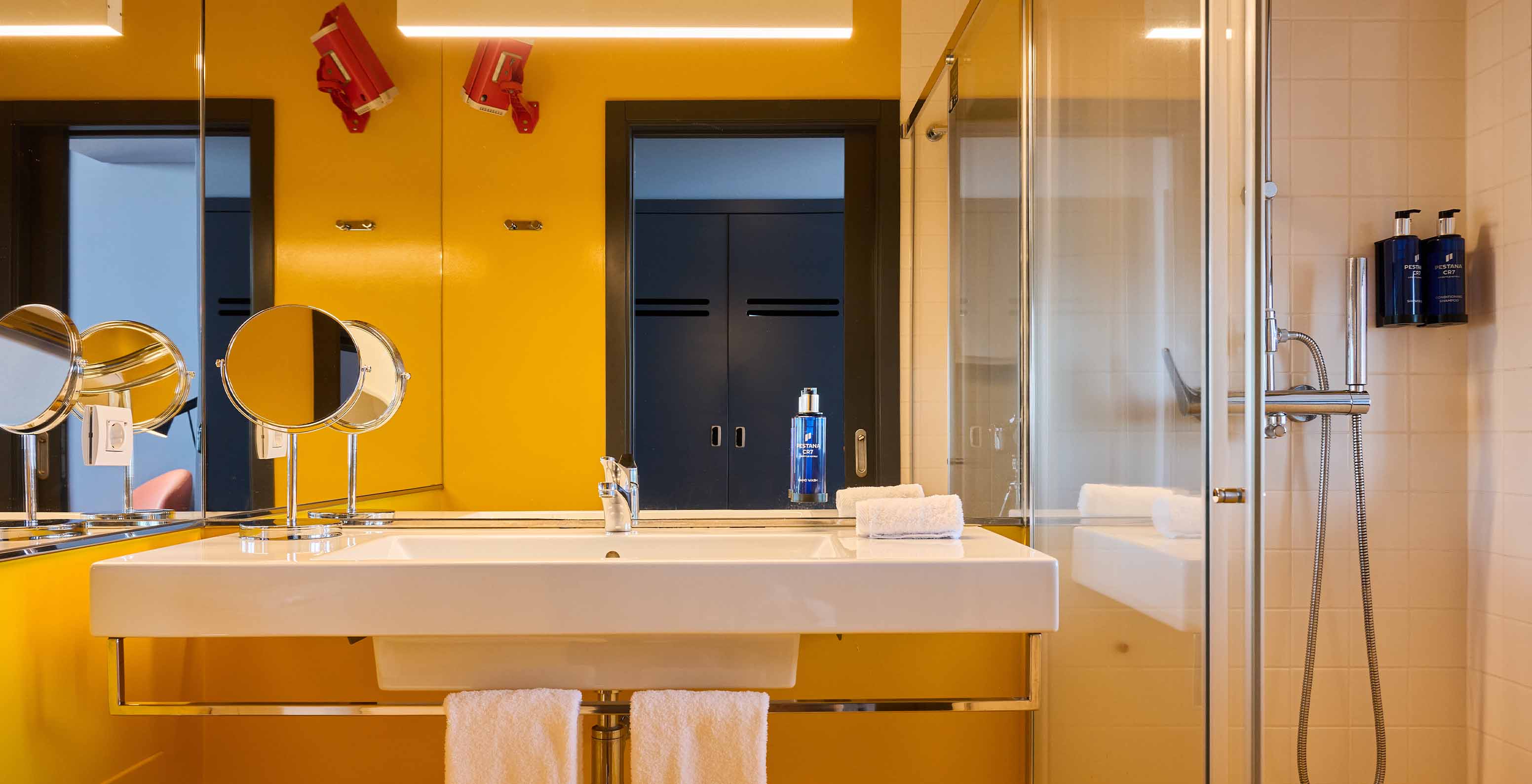 De CR Superior Room van Pestana CR7 Funchal heeft een moderne badkamer in gele tinten met een douche