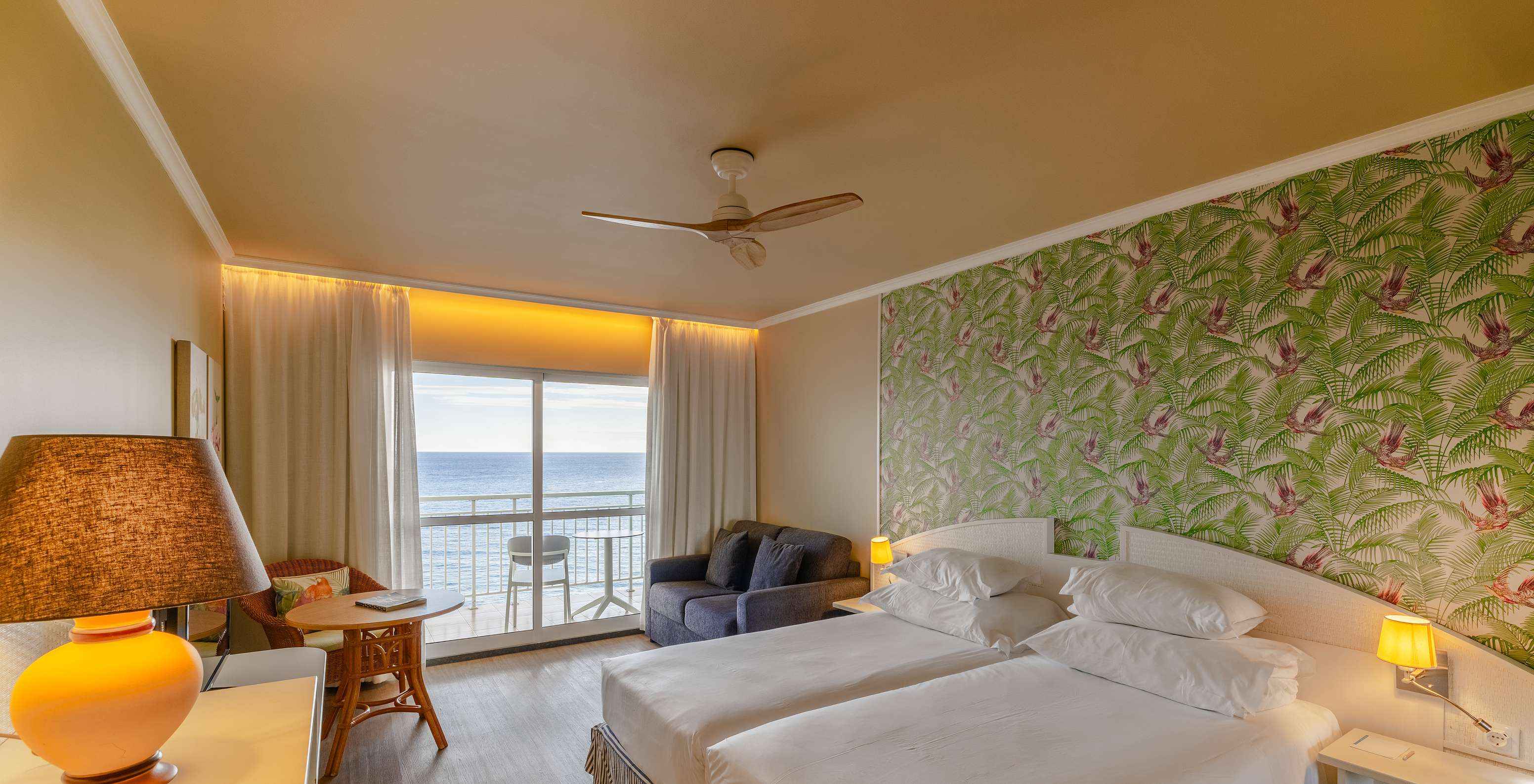 De Premium Sea View van het Pestana Ocean Bay All Inclusive heeft een tweepersoonsbed, behang en een bank