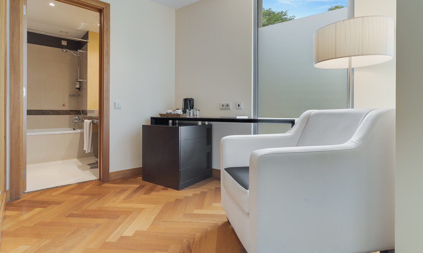 De Klassieke Twin van Pestana Promenade heeft een badkamer met bad en heeft een fauteuil en een tafel bij de deur