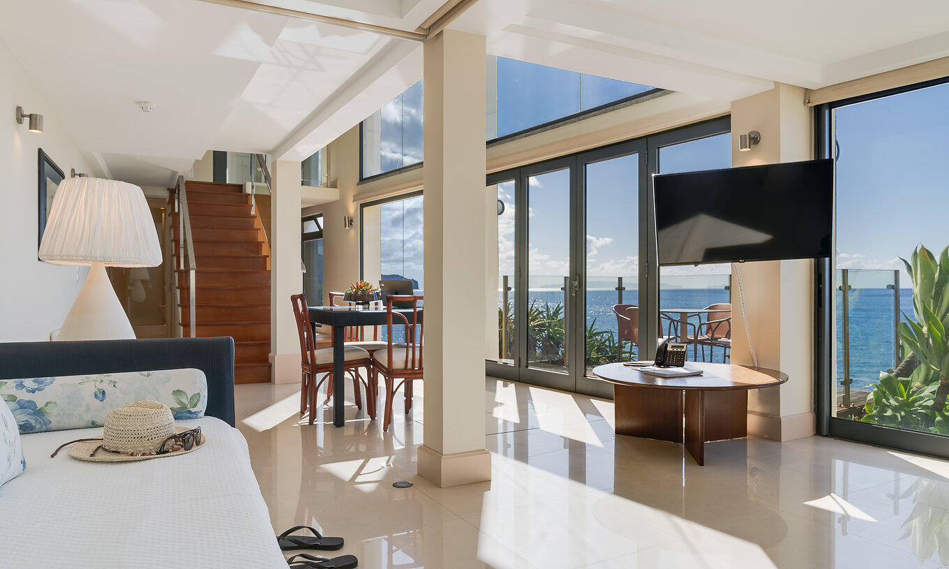 De Duplex Suite Sea View van Pestana Vila Lido Madeira heeft een ruime woonkamer met uitzicht op het zout, bank en eettafel