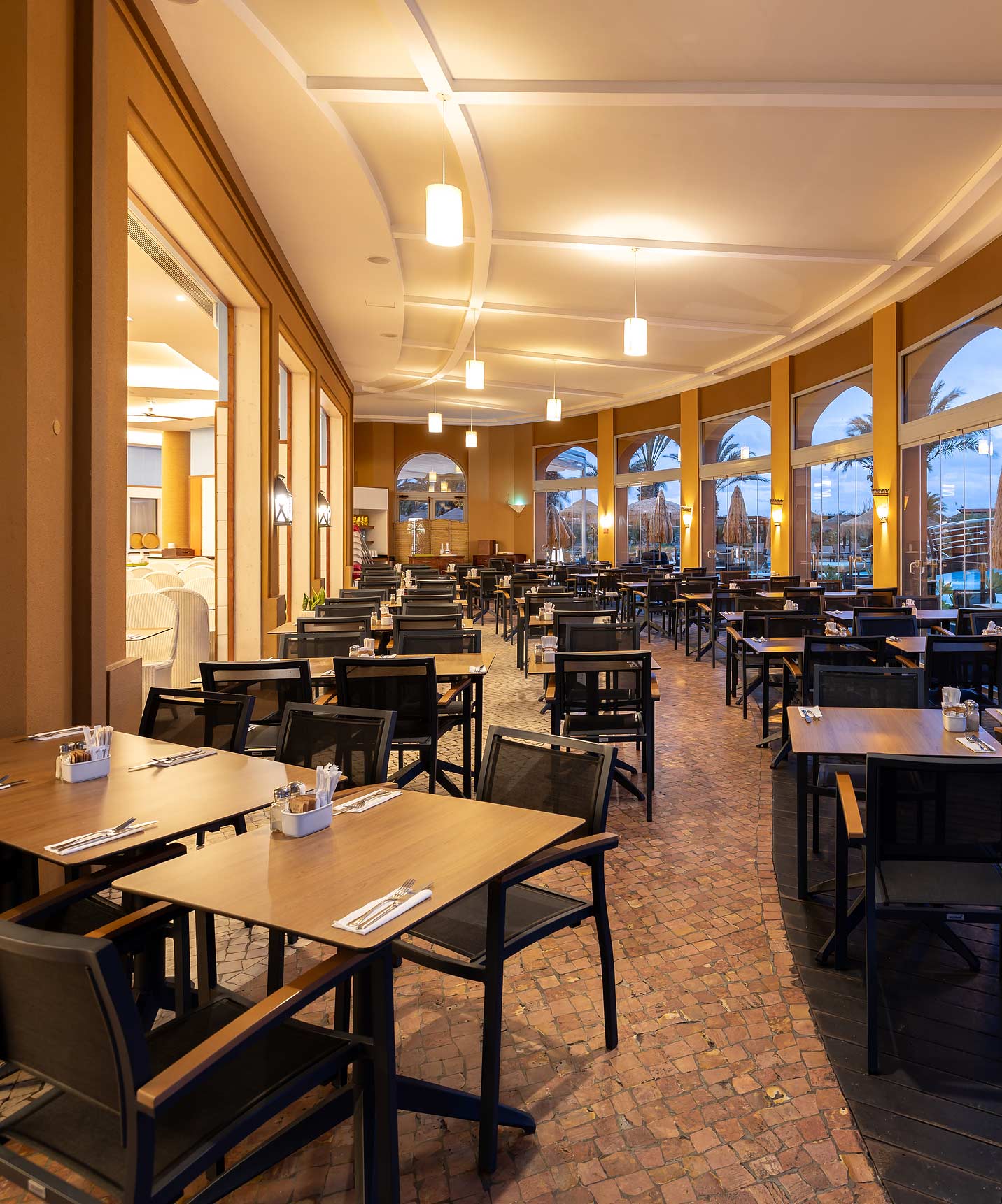 Informele eetzaal van Pestana Porto Santo All Inclusive met verschillende vierkante tafels en stoelen