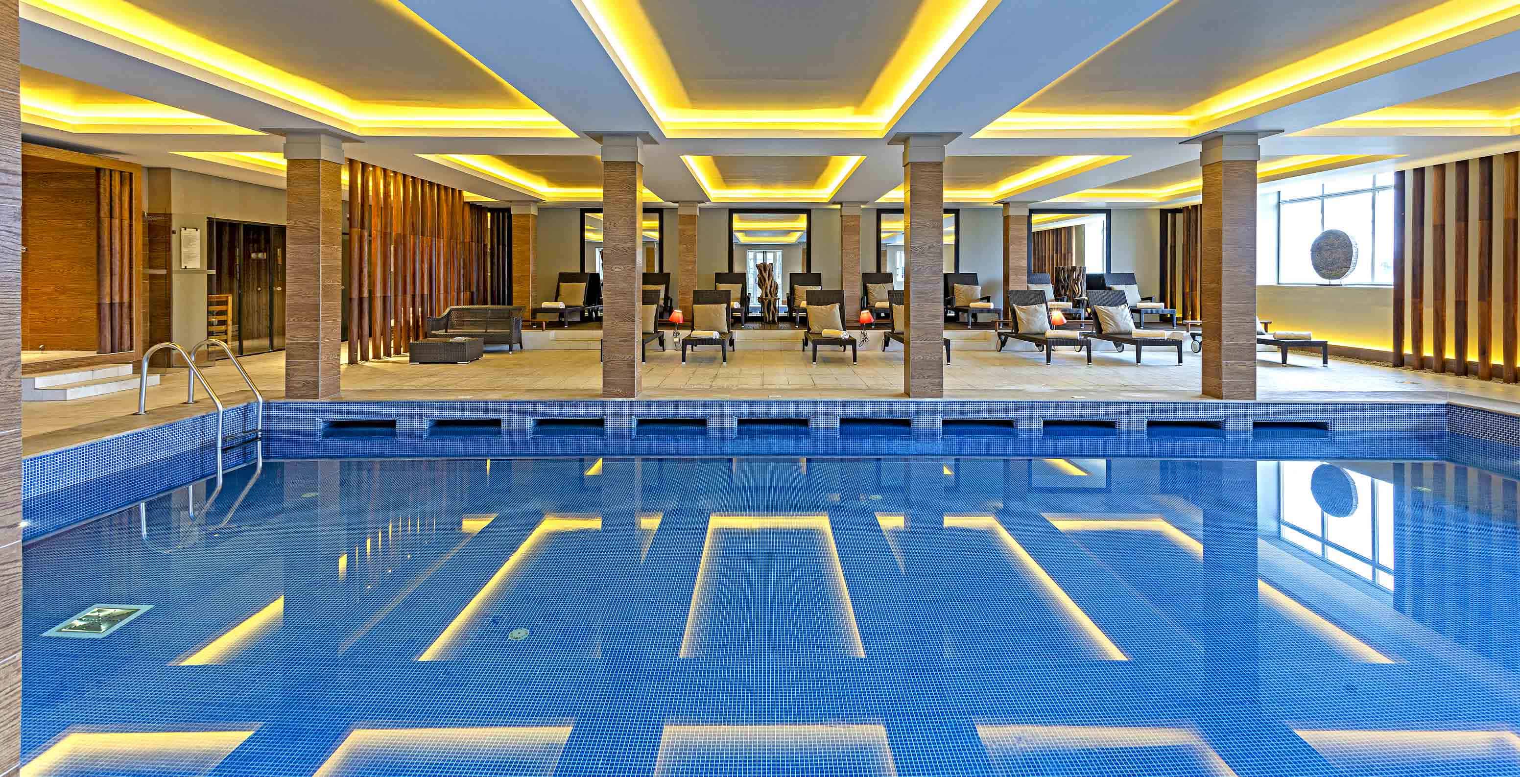 Overdekt zwembad met ligstoelen bij Pestana Palácio do Freixo, een historisch hotel aan de oever van de Douro