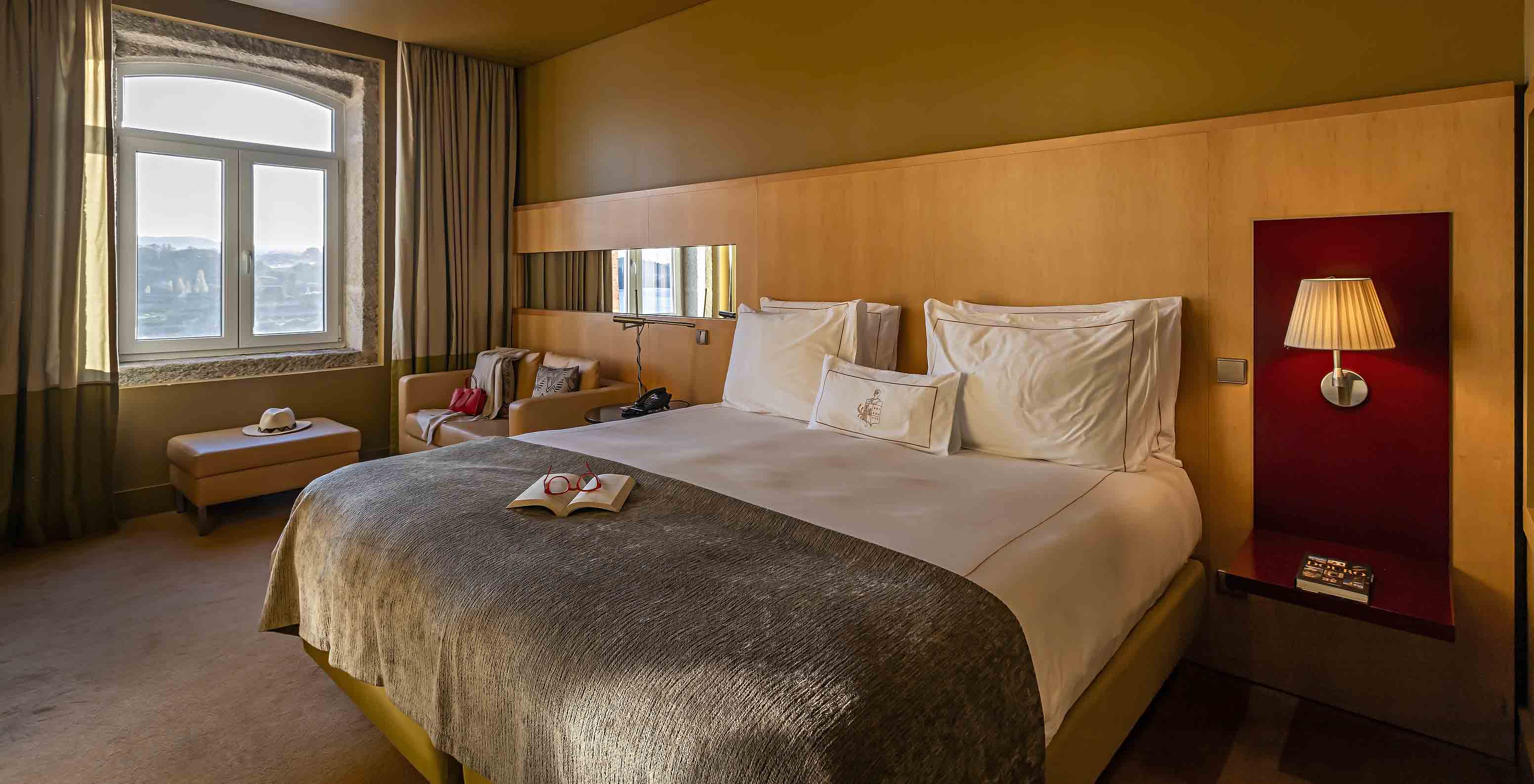 De Executive Superior heeft een tweepersoonsbed, een bank en een poef naast het raam