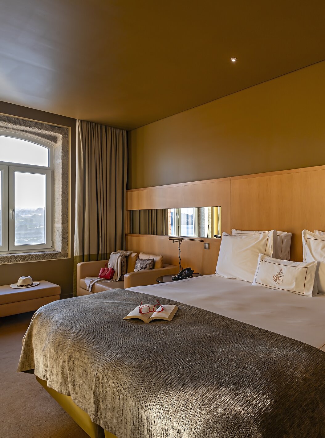 De Executive Superior heeft een tweepersoonsbed, een bank en een poef naast het raam