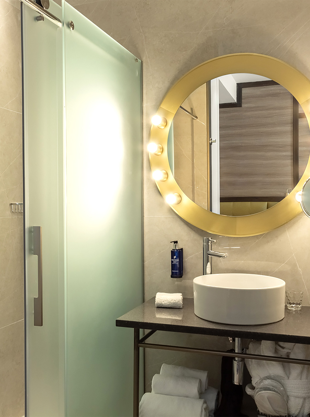 De Deluxe Grand met Uitzicht van Pestana CR7 Gran Vía Madrid heeft een badkamer met een spiegel, wastafel en glazen deuren