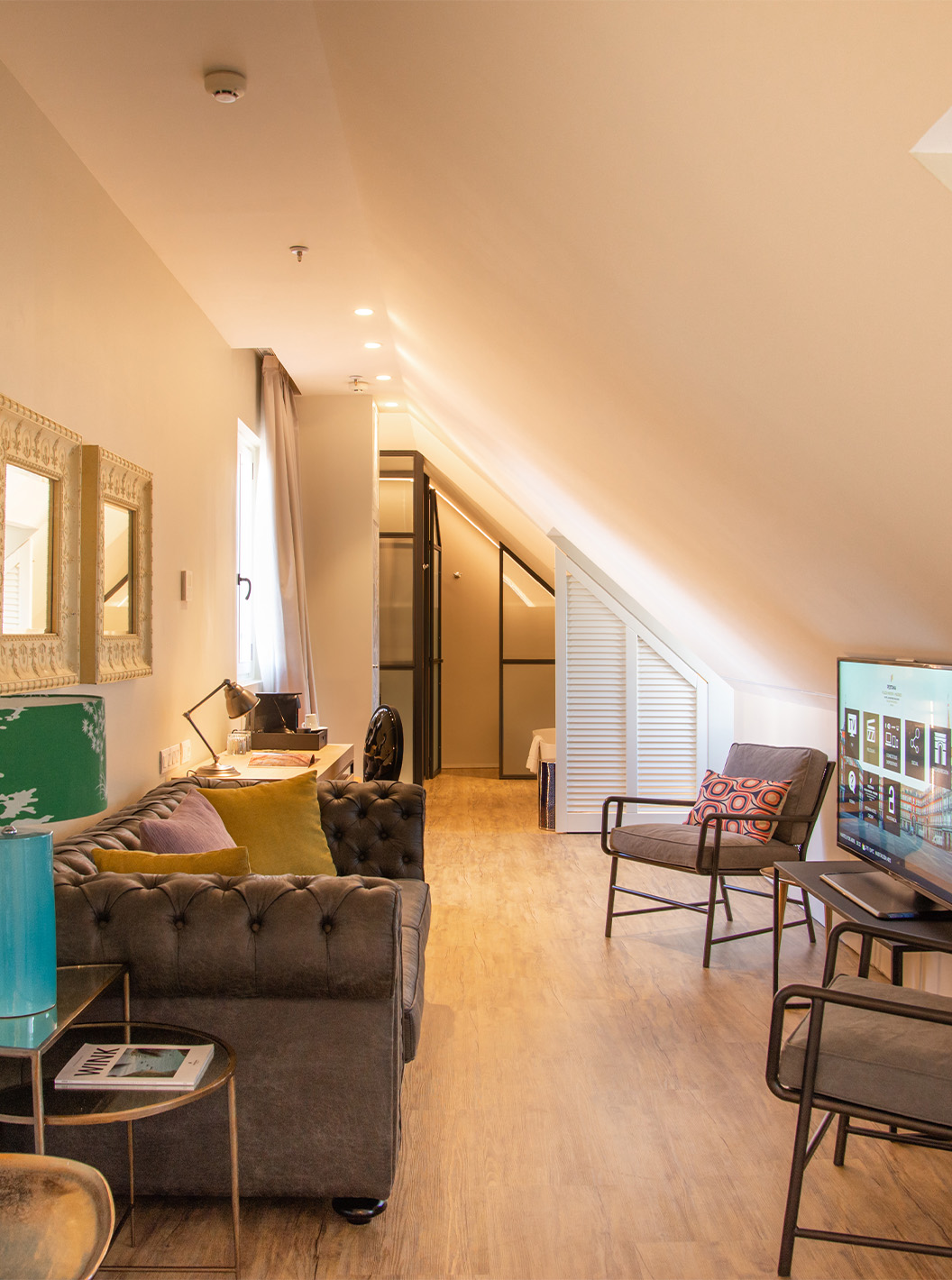 De Suite Plaza Mayor van Pestana Plaza Mayor Madrid heeft een woonkamer met bank stoelen tv en schilderijen aan de muur