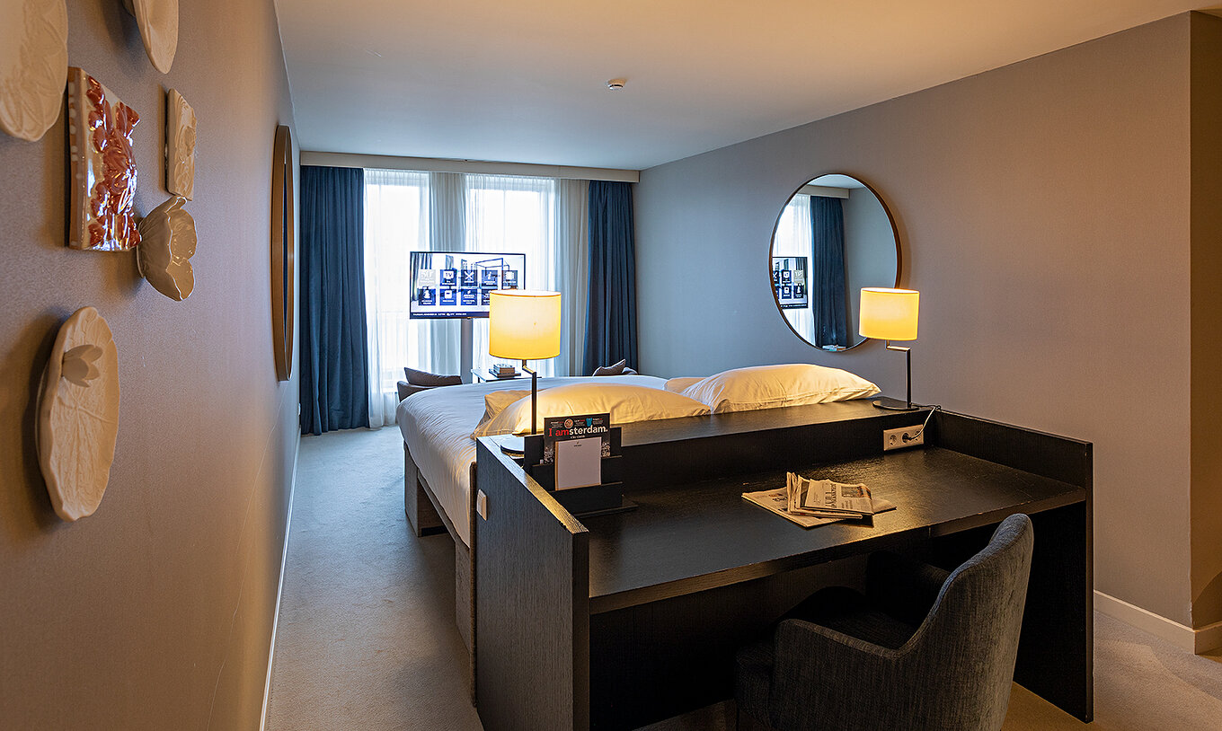 Executive - River View kamer Pestana Amsterdam Riverside heeft televisie voor bed en bureau
