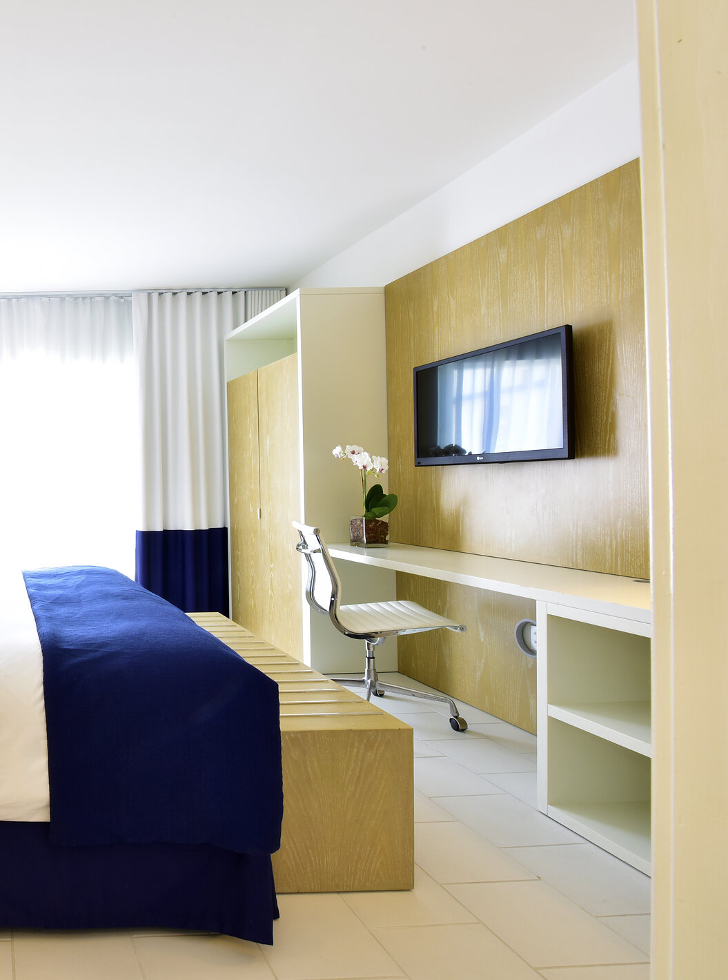 De Suite King met balkon bij Pestana Miami is modern met groot bed en blauw-witte inrichting.