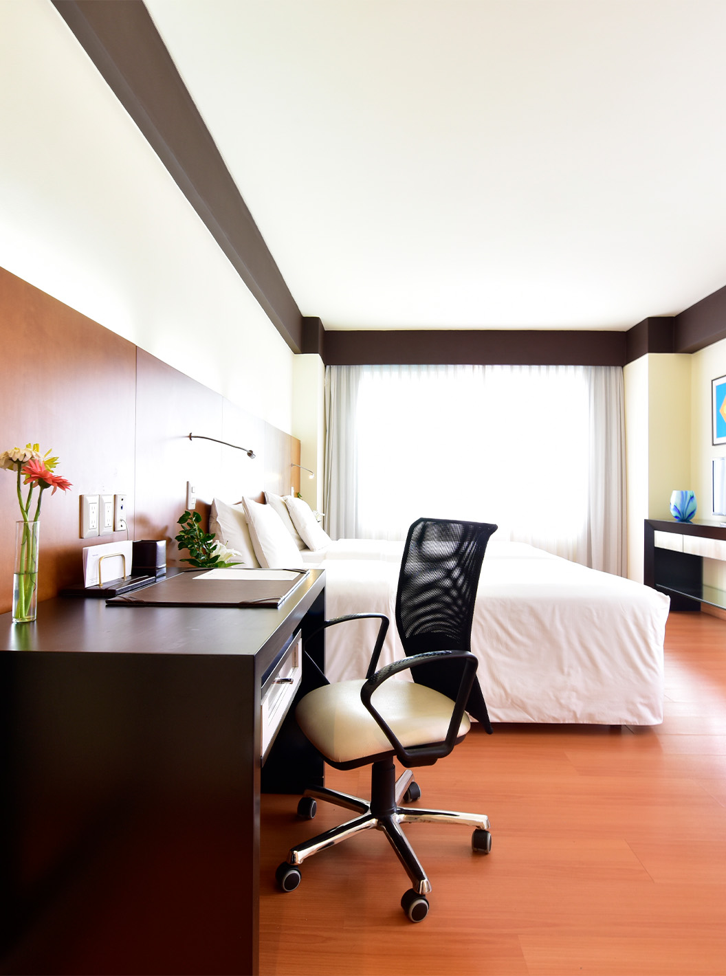 De King Junior Suite van Pestana Caracas heeft een tweepersoonsbed, bureau met ergonomische stoel en een fauteuil