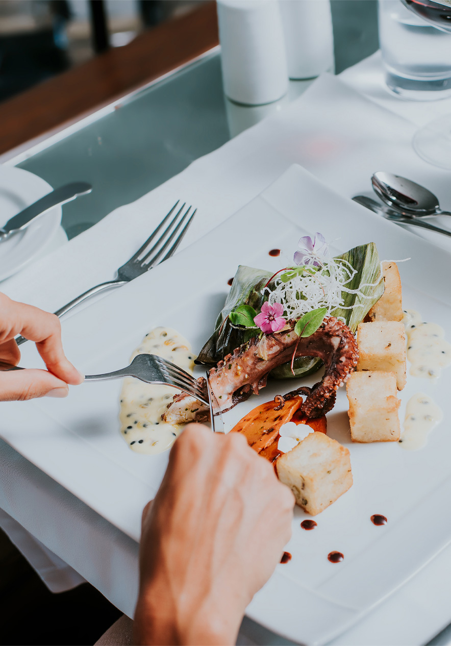 Wit bord met octopus en gebakken maïs, tijdens een maaltijd in een hotel van Pestana Hotels and Resorts