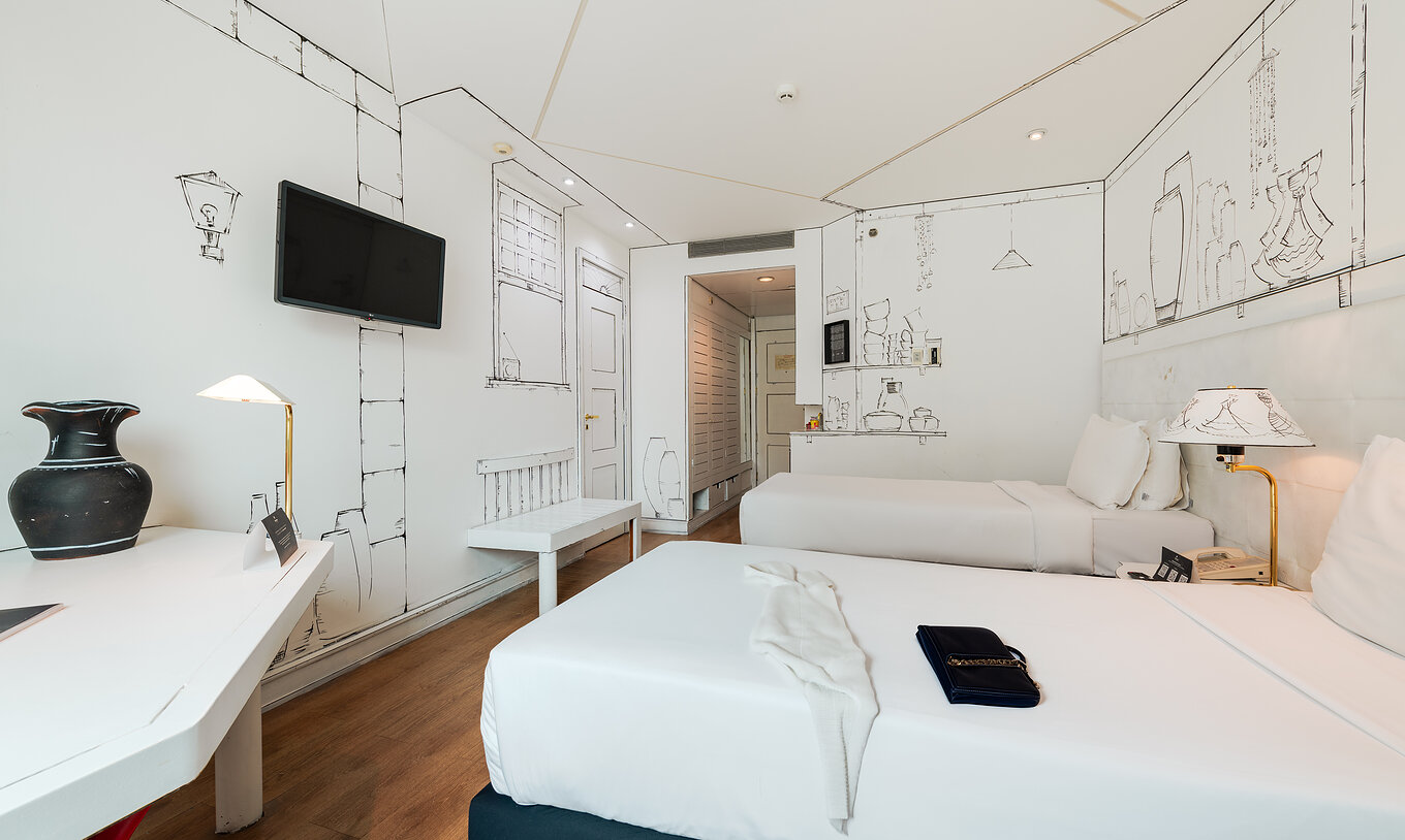 O Art Room do Pestana São Paulo tem duas camas e pinturas na parede em preto e branco de utensílios do artista Elano Passos