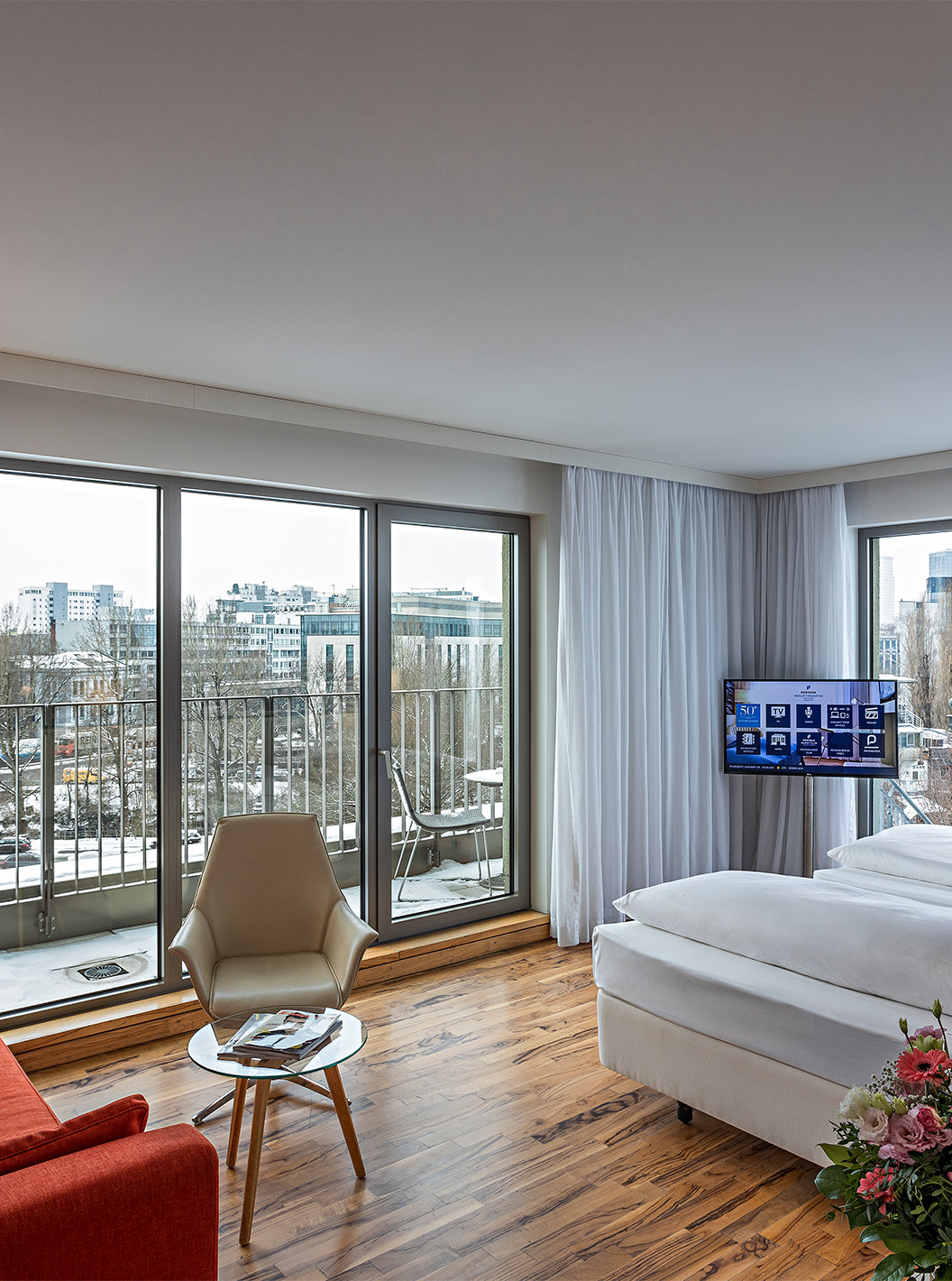 O Quarto Premium com Varanda Panorâmica do Pestana Berlin Tiergarten conta com um sofá com candeeiro, televisão e cama