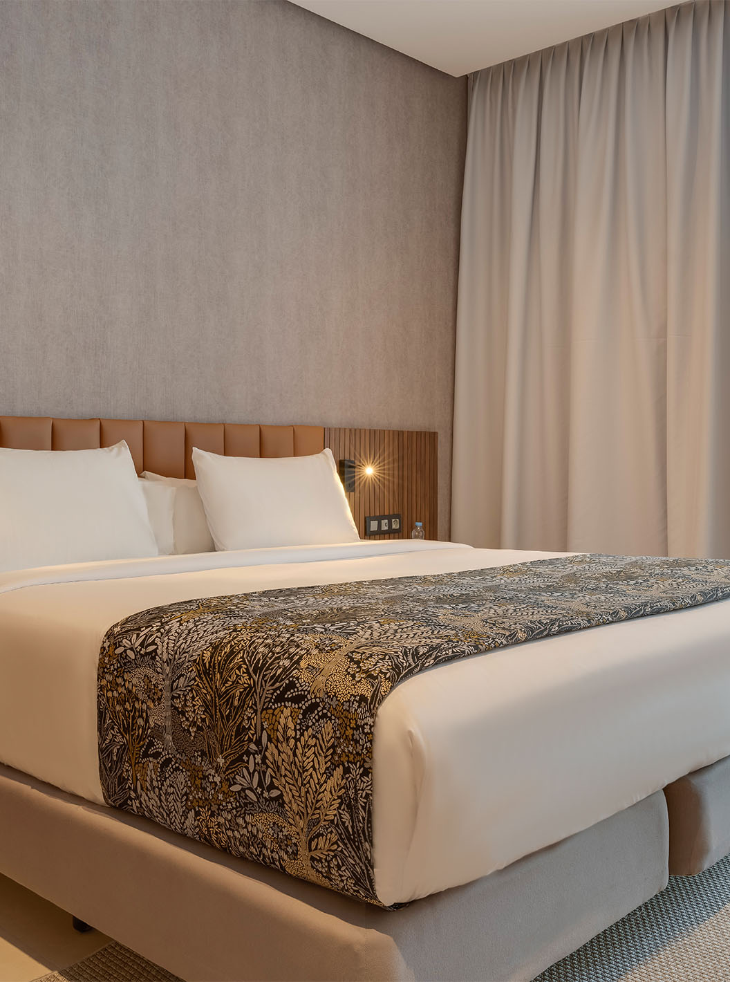 A Suite Familiar Premium do Pestana Casablanca tem um quarto com uma cama de casal com uma decoração moderna