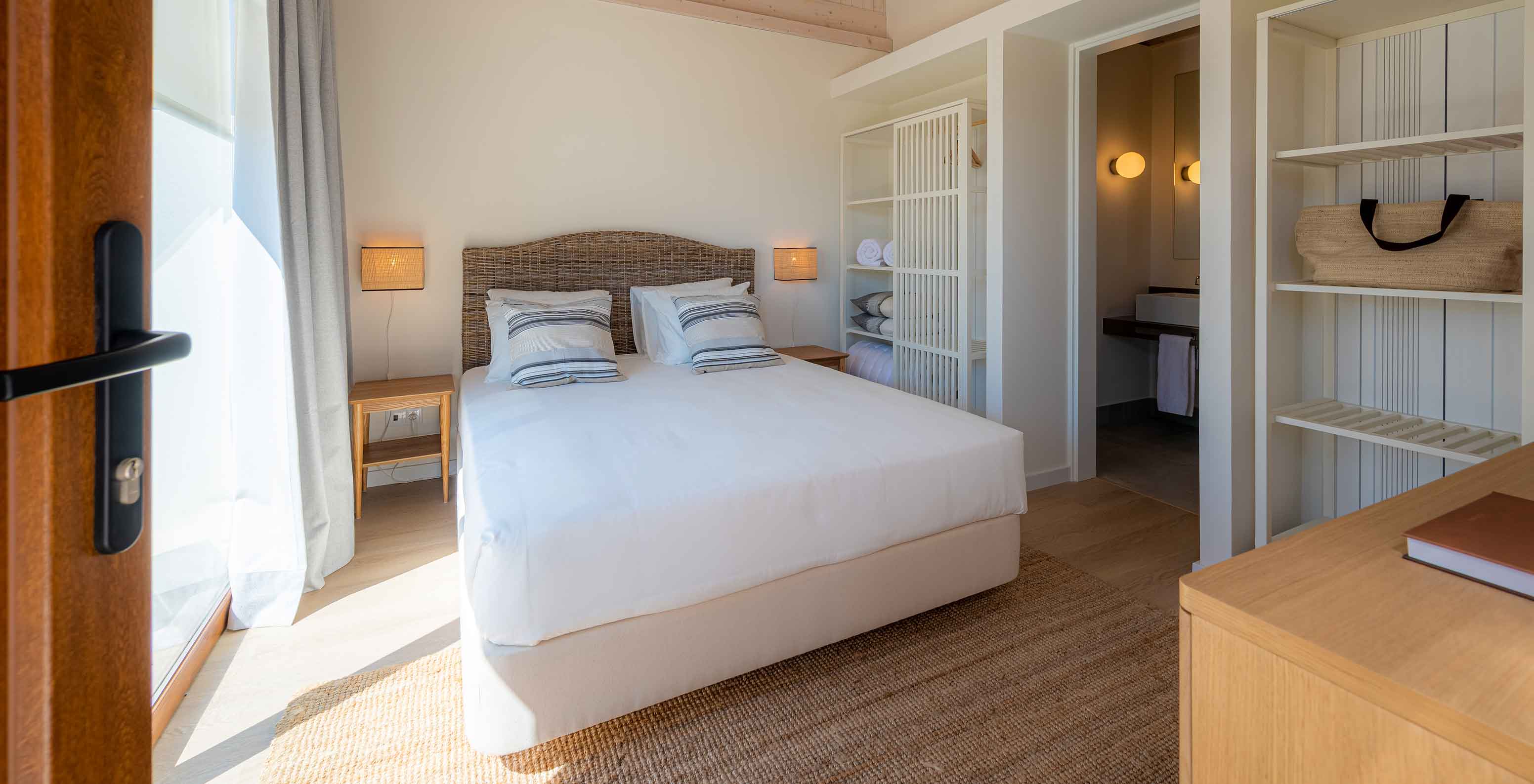 A Standard Villa T2 do Pestana Comporta Village Residences tem um quarto com uma cama de casal e uma decoração simples