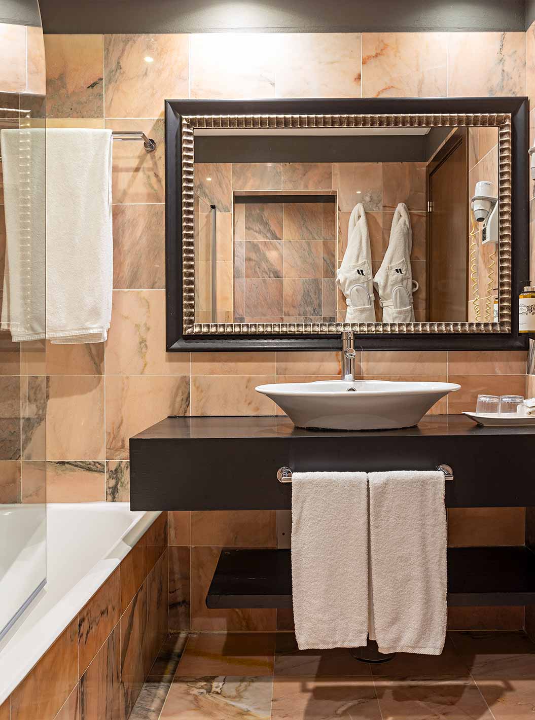 A Cliff Studio do Pestana Alvor Praia tem uma casa de banho com uma banheira, dois roupões e um secador de cabelo