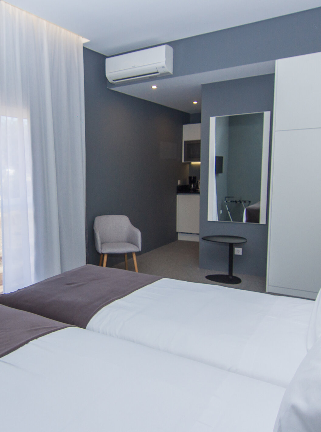 O Quarto Clássico do Pestana Gramacho Residences tem duas camas individuais, ar condicionado, uma janela e um espelho