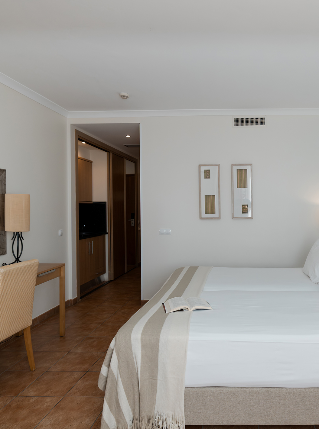 O Deluxe Vista Mar do Pestana Viking tem duas camas, mesa de cabeceira e uma secretária com cadeira