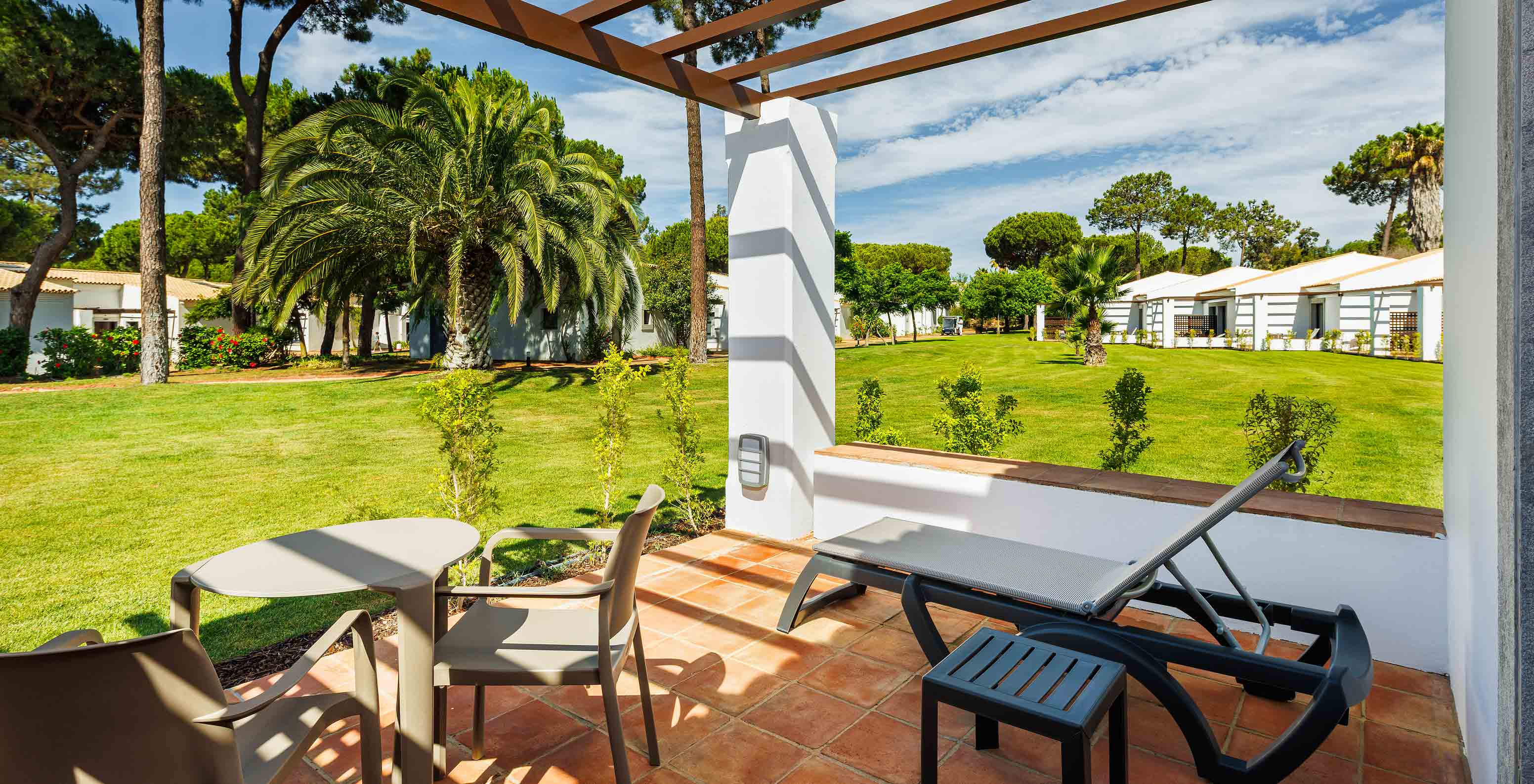 O Superior Vista Jardim do Pestana Vila Sol - Vilamoura tem uma varanda com espreguiçadeira, mesa e vista para o jardim