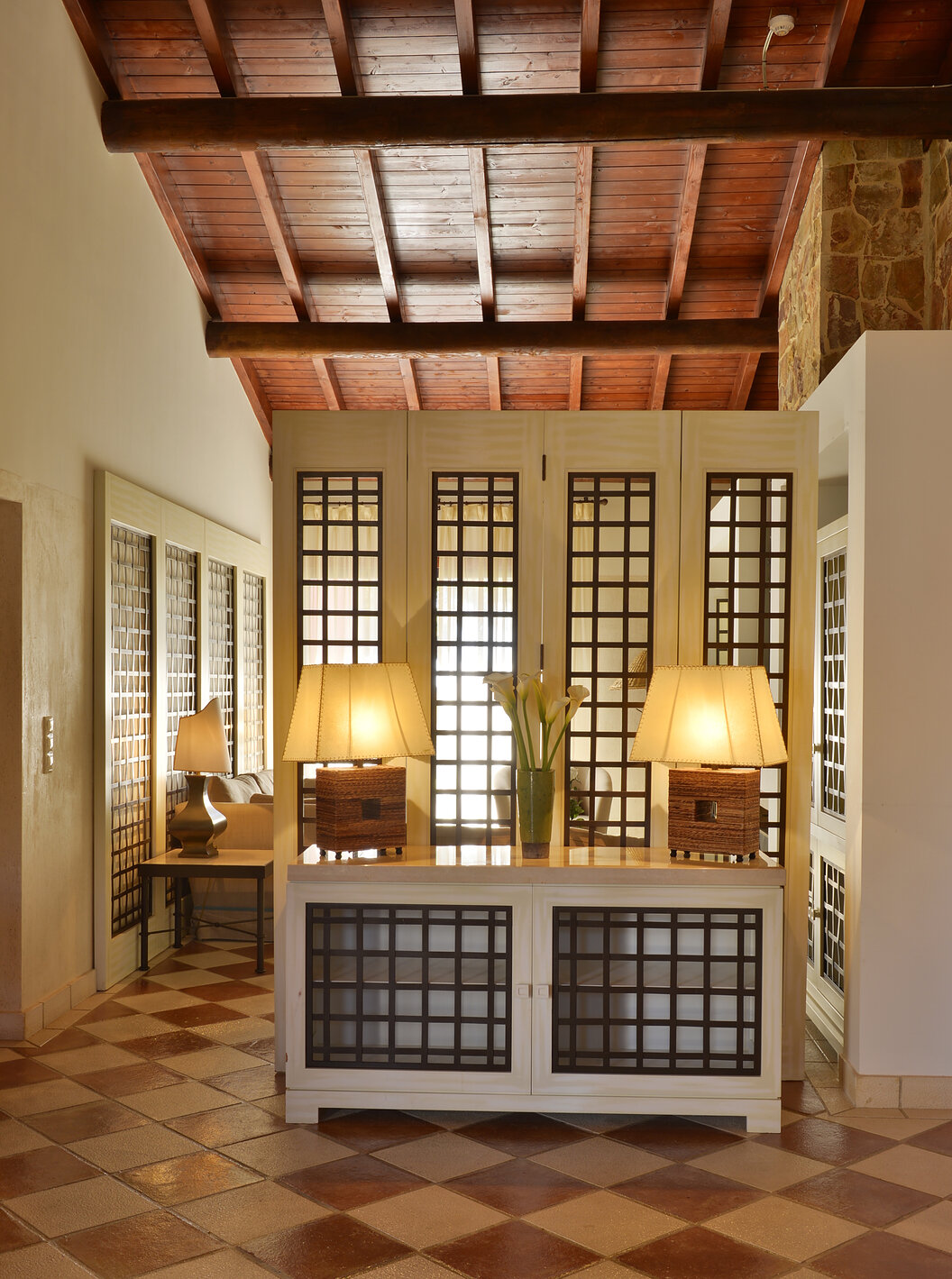 A Suite Vista Jardim Vila Sol do Pestana Vila Sol - Vilamoura tem uma entrada com uma mesa com dois candeeiros e um jarro