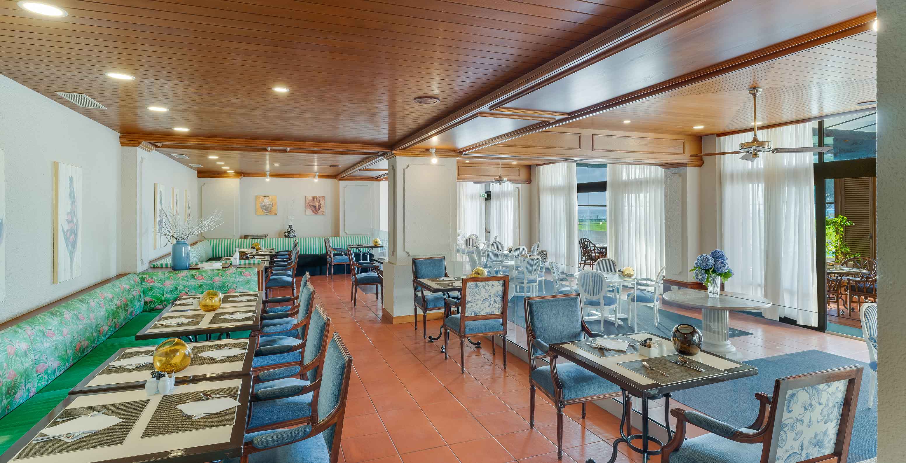 Interior do restaurante Lugar da Praia no Pestana Bahia Praia com mesas postas, cadeiras e decoração moderna