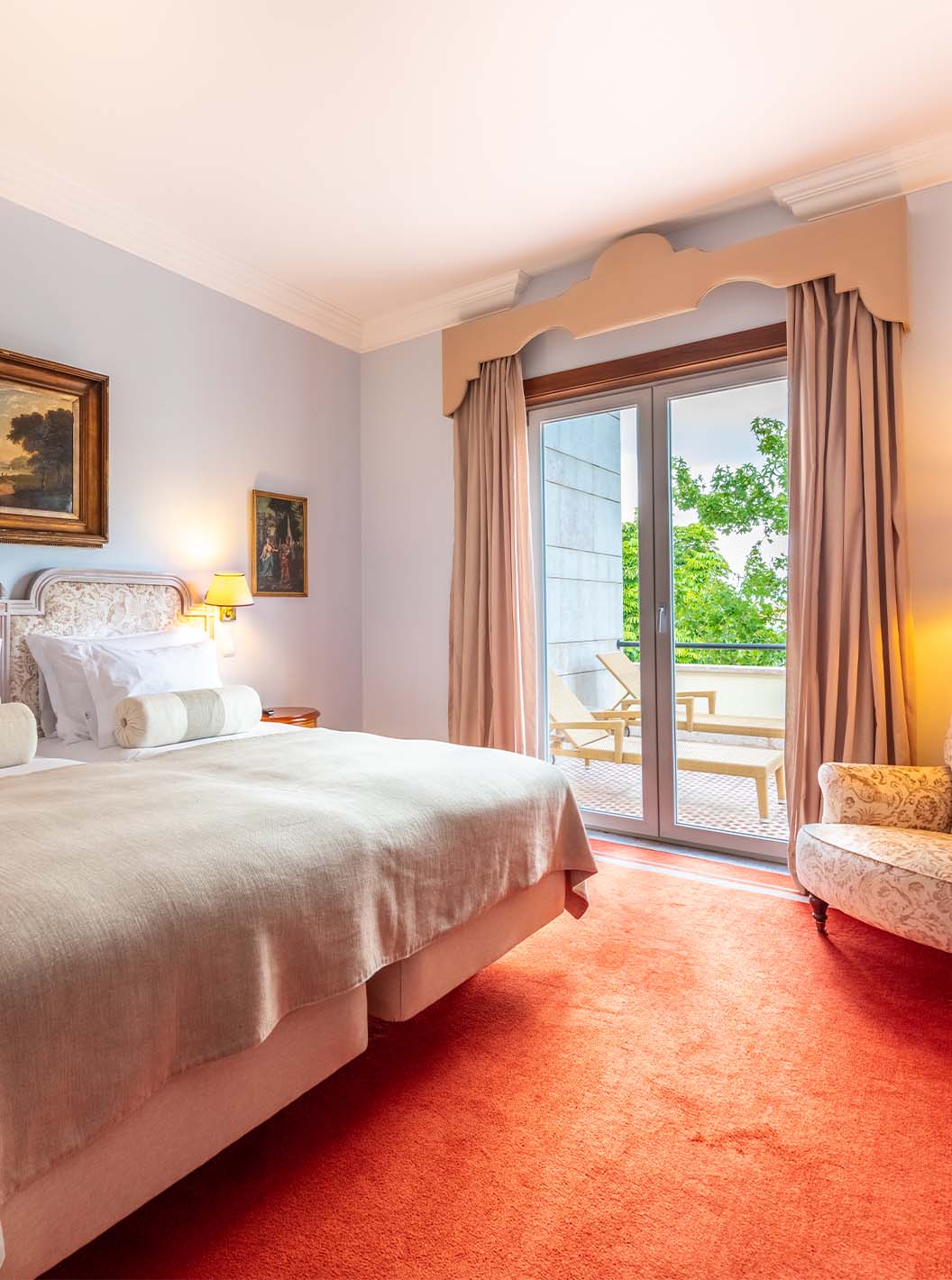 A Suite Collection do Pestana Palace Lisboa tem uma cama de casal, uma poltrona, secretária e uma janela com acesso ao jardim
